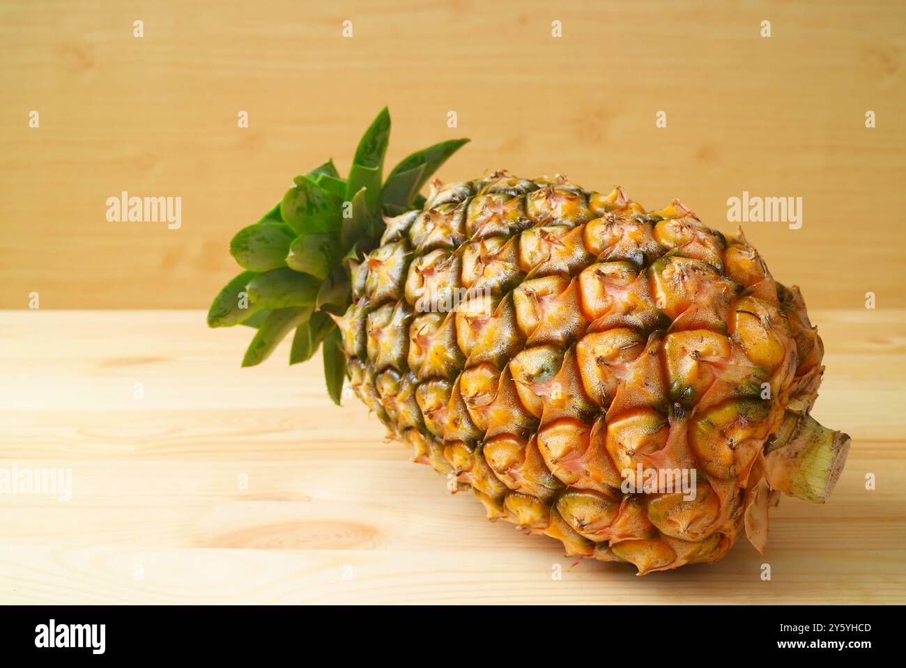 Fruit d'ananas frais mûr isolé sur fond de bois Banque D'Images