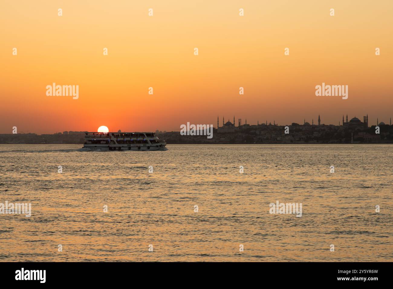 Août 2024 - Istanbul : vue panoramique sur le coucher du soleil du Bosphore avec bateaux et croisières. Horizon avec mosquées en arrière-plan Banque D'Images