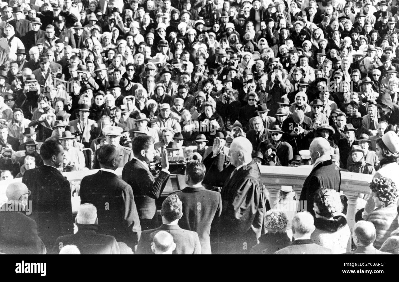 Cette vue de derrière la plate-forme officielle montre les spectateurs regardant John F. Kennedy prêter serment en tant que président des États-Unis, le 20 janvier 1961. LtoR sont l'ancien vice-président Richard Nixon ; le vice-président Lyndon Johnson ; le président Kennedy ; James R Browning, greffier de la Cour suprême des États-Unis ; le juge en chef Earl Warren ; l'ancien président Eisenhower, et Mme Jackie Kennedy, épouse du nouveau président. WASHINGTON DC, USA22 JANVIER 1961 Banque D'Images