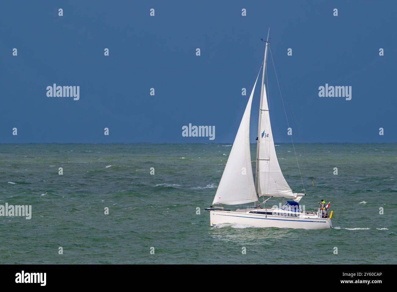 Voilier naviguant le long de la côte de la mer du Nord en Zélande, pays-Bas par un jour de pluie par mauvais temps Banque D'Images