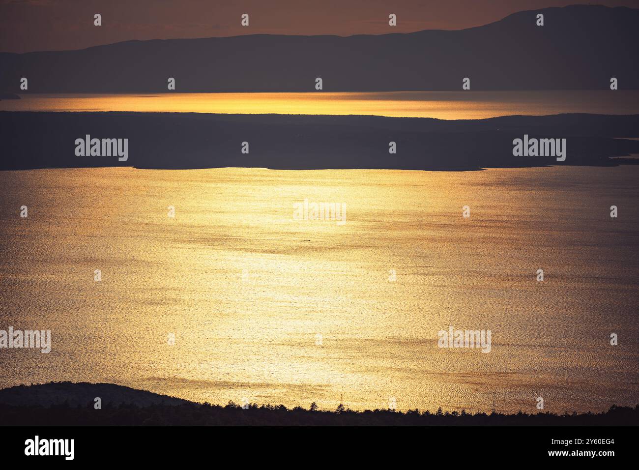 La lumière du soleil couchant se reflète dans l'eau saccadée. Banque D'Images