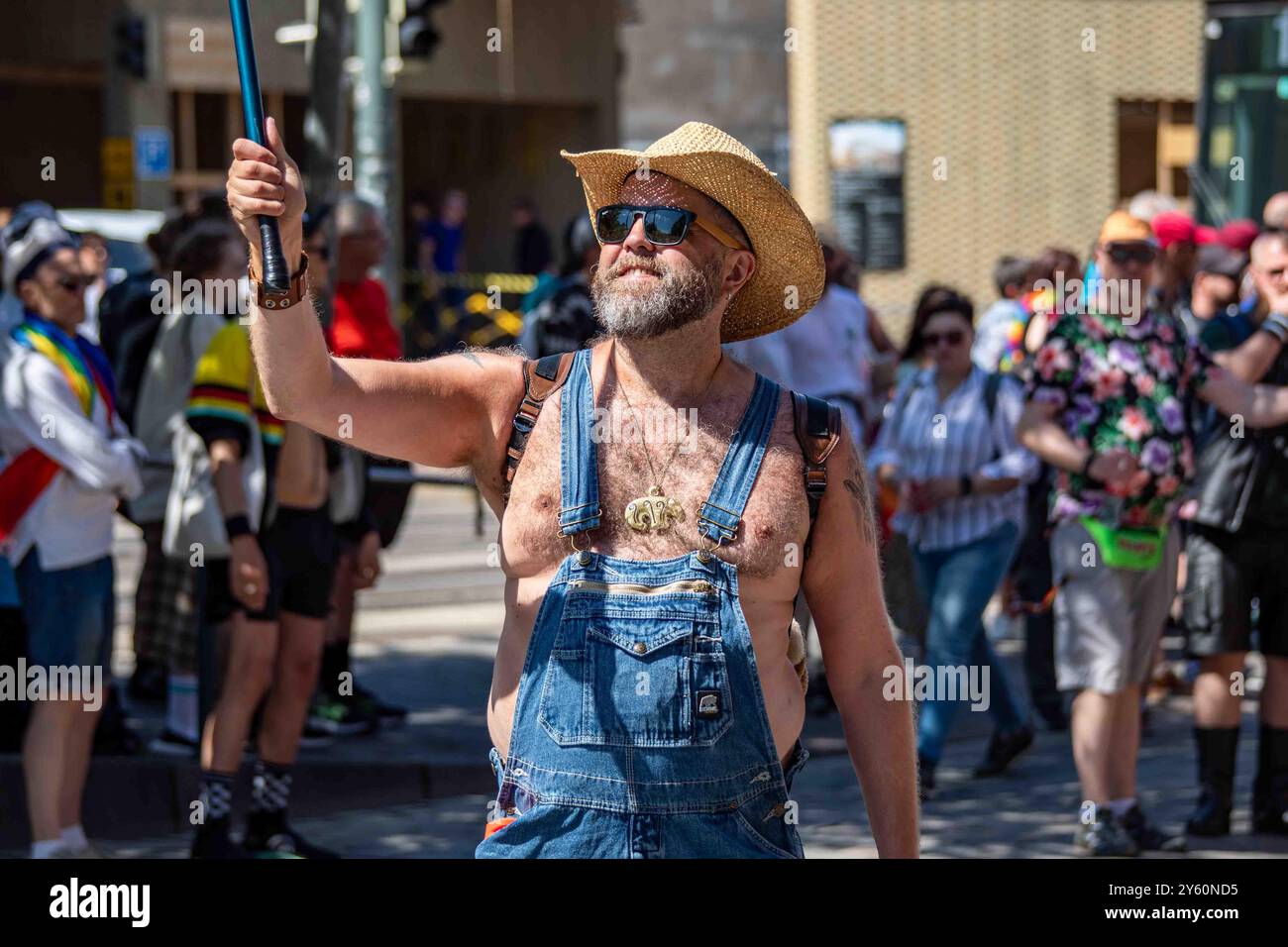 Homme barbu - un ours - portant des lunettes de soleil, une salopette en Jean et un chapeau de cow-boy en paille au défilé Helsinki Pride 2024 sur Mannerheimintie à Helsinki, Finlande Banque D'Images