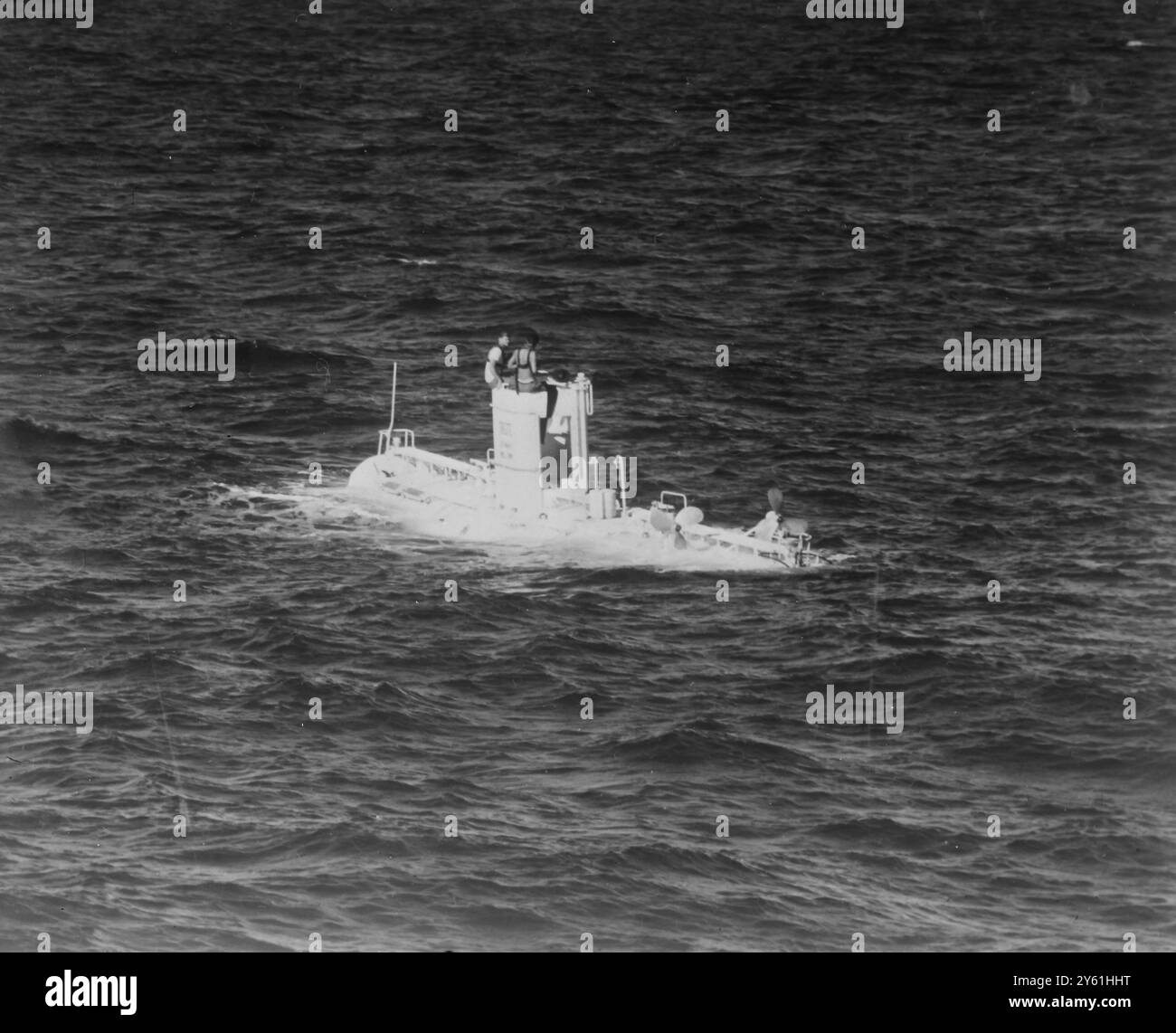 Guam , Maarianas : la marine américaine Bathyscaphe ' Trieste ' fait surface ici après un record de plongée océanique à 18 600 pieds en novembre 1959 . Sur la tour conning se trouvent le Dr Andrea B Rechnitzer (à gauche) et Jacques Piccard , les deux hommes qui étaient aux commandes . Le navire de 70 tonnes a battu le record de 13 400 pieds dans sa première plongée profonde dans une série d'explorations pour recueillir des données scientifiques dans des régions jamais entrées par l'homme. Un flotteur en acier , 50 pieds de long et 11 pieds de profondeur fournit la flottabilité . Sous ce flotteur se trouve une cabine de 6 1/2 pieds pour les deux hommes et les instruments de recherche. 14 avril 1960 Banque D'Images