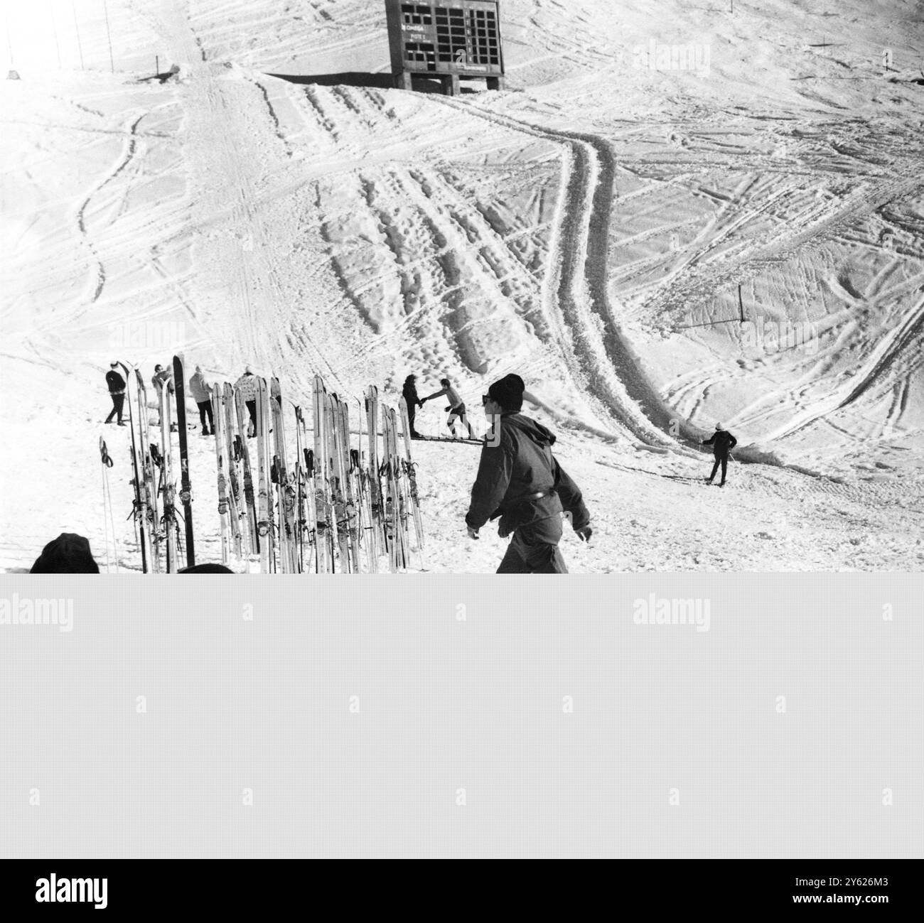 Prendre une pause les troupes alpines de l'armée française qui sont maintenant engagées à maintenir en parfait état les pistes pour les épreuves alpines des prochains Jeux olympiques d'hiver , prendre une pause sur les pentes des pistes de slalom à Chamrousse . En arrière-plan sont vus la ligne d'arrivée des événements de slalom et le bâtiment de presse pour le pointage officiel 18 janvier 1968 Banque D'Images