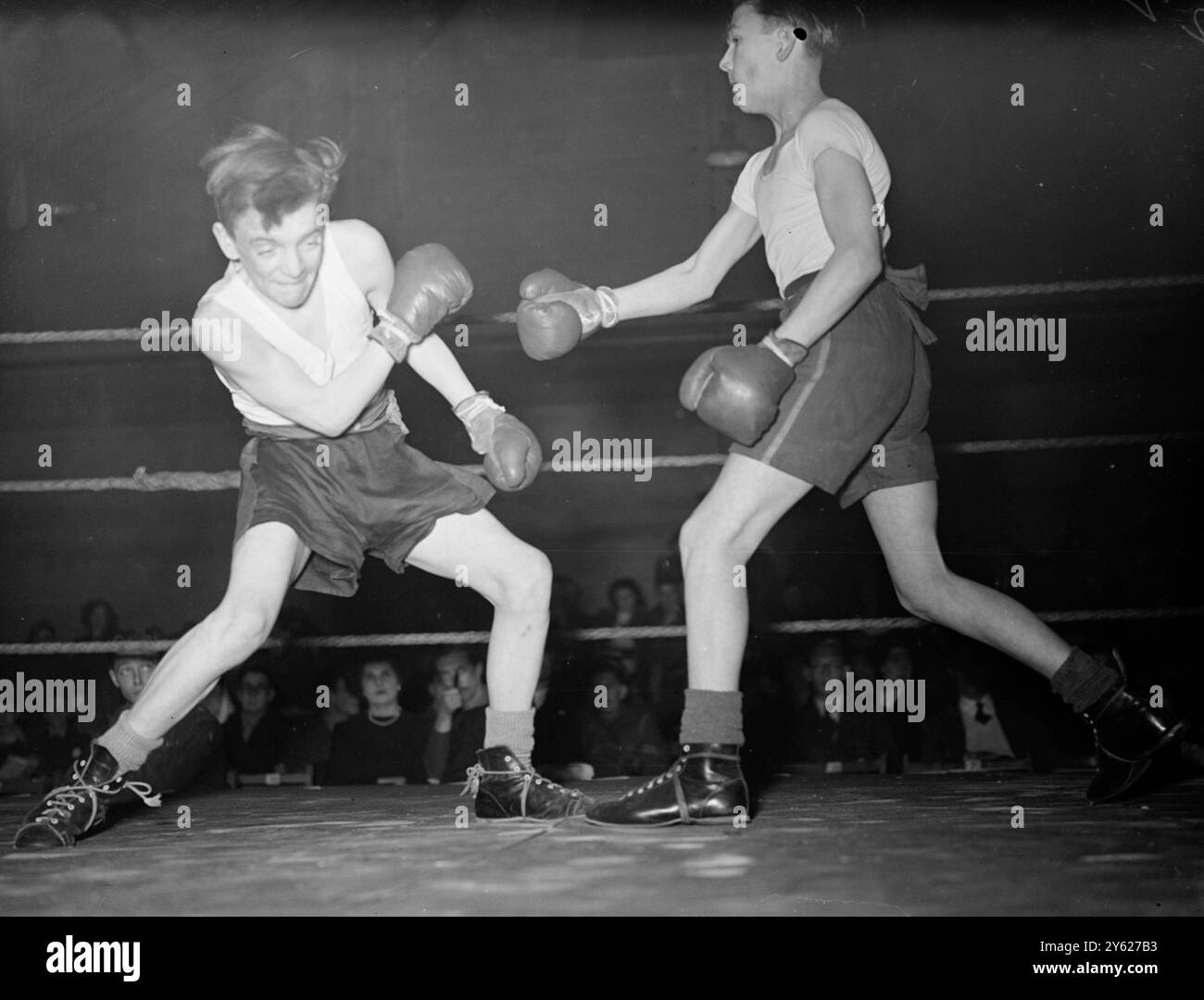 Rifleman J.F. Smith, fournit une étude et une expression déterminée (à gauche), comme dans un style plus «droit» Rifleman Fuller entre à l'attaque, lors de leur combat dans le comté de Londres Army Cadet Force Boxing Championships, à la caserne Duke of Yorks, Chelsea. Les garçons se sont battus dans la classe d'âge de 14-15 1/2 ans. 24 janvier 1948 Banque D'Images Rifleman J.F. Smith, fournit une étude et une expression déterminée (à gauche), comme dans un style plus «droit» Rifleman Fuller entre à l'attaque, lors de leur combat dans le comté de Londres Army Cadet Force Boxing Championships, à la caserne Duke of Yorks, Chelsea. Les garçons se sont battus dans la classe d'âge de 14-15 1/2 ans. 24 janvier 1948 Banque D'Images