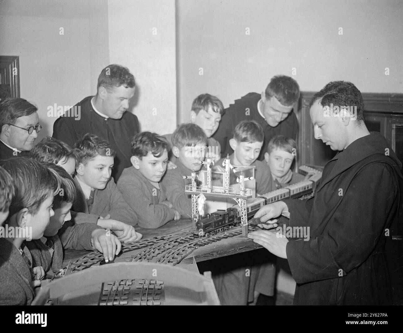 Quatorze moines qui sont venus de Downside Abbey dans le Somerset pour établir le monastère bénédictin à Londres, font l'histoire pour l'ordre. Le premier monastère bénédictin indépendant depuis la réforme il y a 400 ans a été établi au Prieuré Saint-Benoît, à Ealing, où le prieur Charles Pontifex a désigné la moitié de ses moines pour travailler parmi les habitants de la paroisse et l'autre moitié pour enseigner à 400 garçons à l'école voisine. Dans le bâtiment de l'école se trouve un énorme chemin de fer électrique, complet jusqu'au dernier signal. Le modèle a été construit par les garçons avec l'aide de membres de l'ordre. Fig Banque D'Images