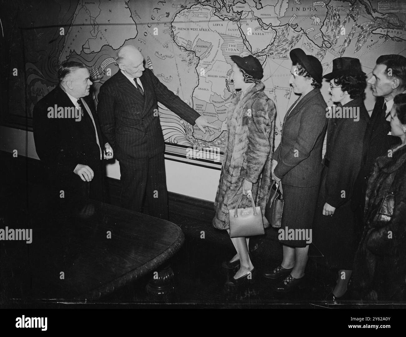 Un groupe d'enseignants britanniques qui partiront bientôt pour enseigner dans des salles de classe sud-africaines sur une base d'échange avec d'autres enseignants africains qui viendront ici, a assisté ce matin à une conférence sur le projet à l'Institut impérial de South Kensington. Le très honorable George Tomlinson, Ministre de l'éducation, a ouvert la conférence et l'Assemblée a entendu une allocution de M. G. Heaton Nicholls, Haut Commissaire de l'Afrique du Sud. Images : M. Nichols indique sur une carte les endroits où les enseignants britanniques serviront. De gauche à droite se trouvent Mlle M. McQuarrie et M.G.J. McDonald de Glasgow, qui wi Banque D'Images