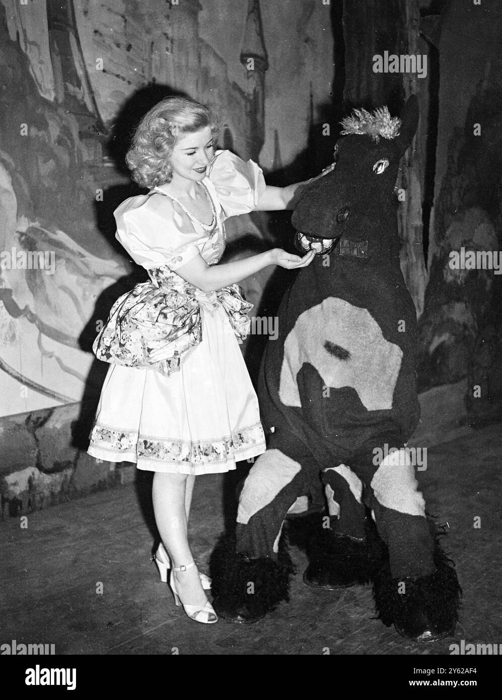 « Babes in the Wood », la pantomime de cette année au Princes Theatre de Londres, va certainement commencer un favori des enfants de tous âges à Noël. Le spectacle avec Eddi Gray, « Monsewer » dans le rôle du baron méchant, Jill Manners dans le rôle de Robin des bois et Kathleen Moody dans le rôle de Maid Marion, débute la veille de Noël. Photos : Kathleen Moody dans le rôle de Maid Marion, photographiée avec le cheval comique pendant les répétitions. 17 décembre 1947 Banque D'Images
