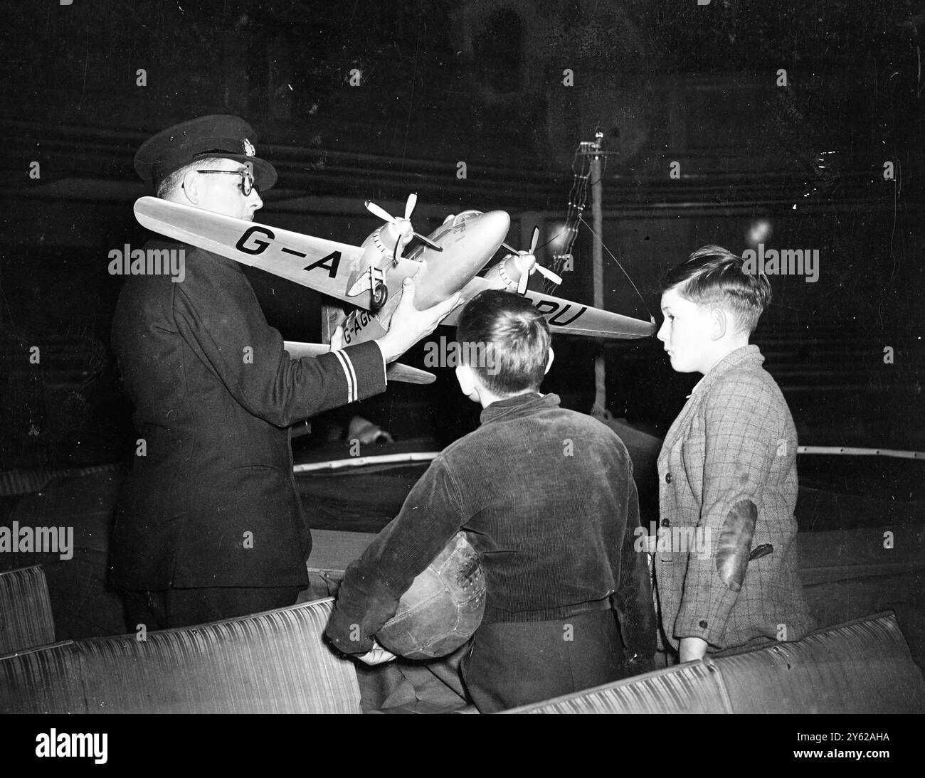 Une exposition, intitulée 'Highways of the Air' et mise en scène pour démontrer l'effet du transport aérien moderne sur la façon dont l'homme regarde le monde, ouvrira au siège de la Royal Geographic Society à Kensington le 22 décembre à Gore. Le Ministère de l'aviation civile et les sociétés aériennes ont coopéré avec des sponsors et organisé l'exposition, à laquelle toutes les organisations scolaires ont été invitées. Images : Percy Oakley (à gauche) et Ian Fraser, deux garçons de Kensington qui sont allés à un aperçu de l'exposition directement après le match de football ce matin montrent un vif intérêt pour un s. Banque D'Images