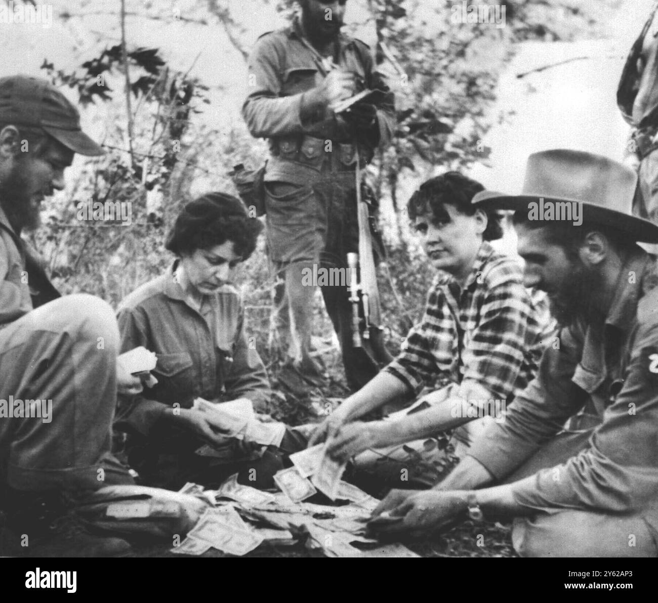 Orient occidental, Cuba. Celia Sanchez (à gauche) officier de liaison entre les armes militaires et civiles du mouvement du 26 juillet, et Maria Hart Santa Maria, une autre femme haut placée dans le mouvement, comptent les factures dans une cargaison d'argent qui est arrivée de Santiago. Le chef rebelle Fidel Castro dit que le mouvement recueille environ 25 000 $ par mois qu'il utilise pour approvisionner ses hommes. Une partie de l'argent va aux agriculteurs de son territoire touchés par la pauvreté. 31 mars 1958. Banque D'Images