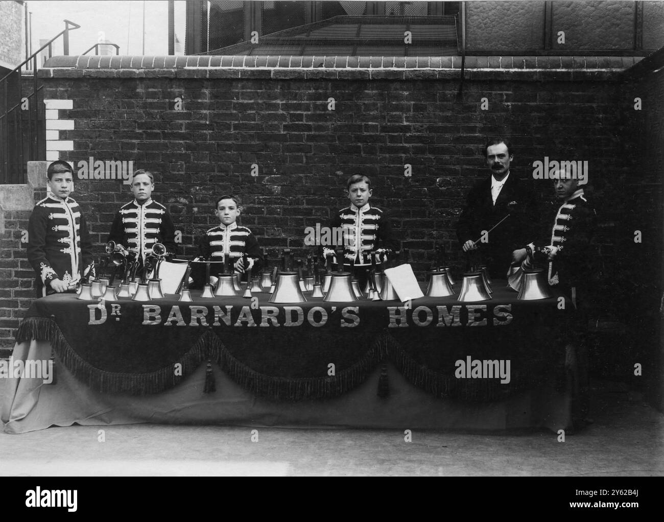 ARCHIVE BOX 6 ARC 0204 RÉFÉRENCE : 001503 BOY HANDBELL RINGERS AUSSI 1884 DATE : C 1895 LES MAISONS DR BARNARDO`S SONNETTES DE MAIN AVEC LEUR CHEF D'ORCHESTRE . MUSIQUE Banque D'Images