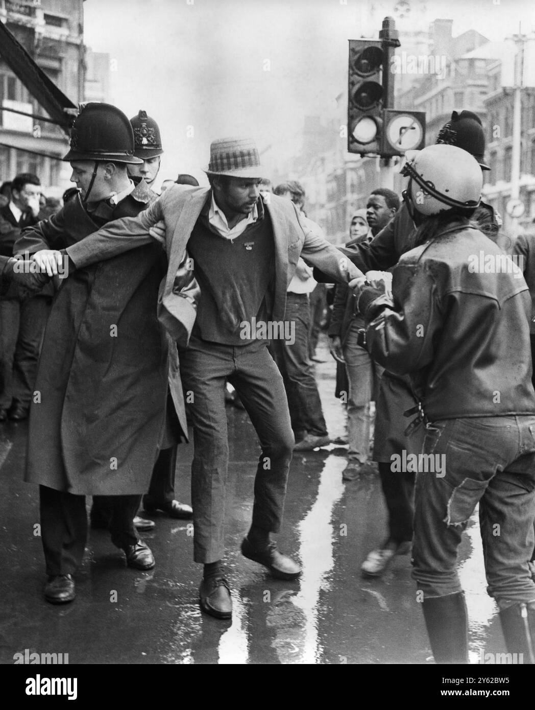 Ses bras sécurisés par deux policiers de la ville, un homme est emmené après une fracas à Ludgate Circus lorsque des manifestants opposés se sont affrontés après des manifestations à Trafalgar Square et Whitehall. Les partisans du mouvement pour la liberté coloniale se sont opposés aux organisateurs du 'peuple Smithfield' d'une marche de 'soutien Enoch Powell'. 7 juillet 1968 Banque D'Images