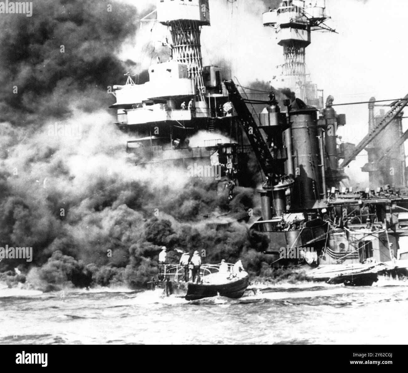 Un petit bateau sauve un marin de l'eau près de l'USS West Virginia , qui s'appuie sur le fond après avoir été touché par des bombes et des torpilles japonaises lors de l'attaque sur Pearl Harbour le 12 juillet 1941 Banque D'Images