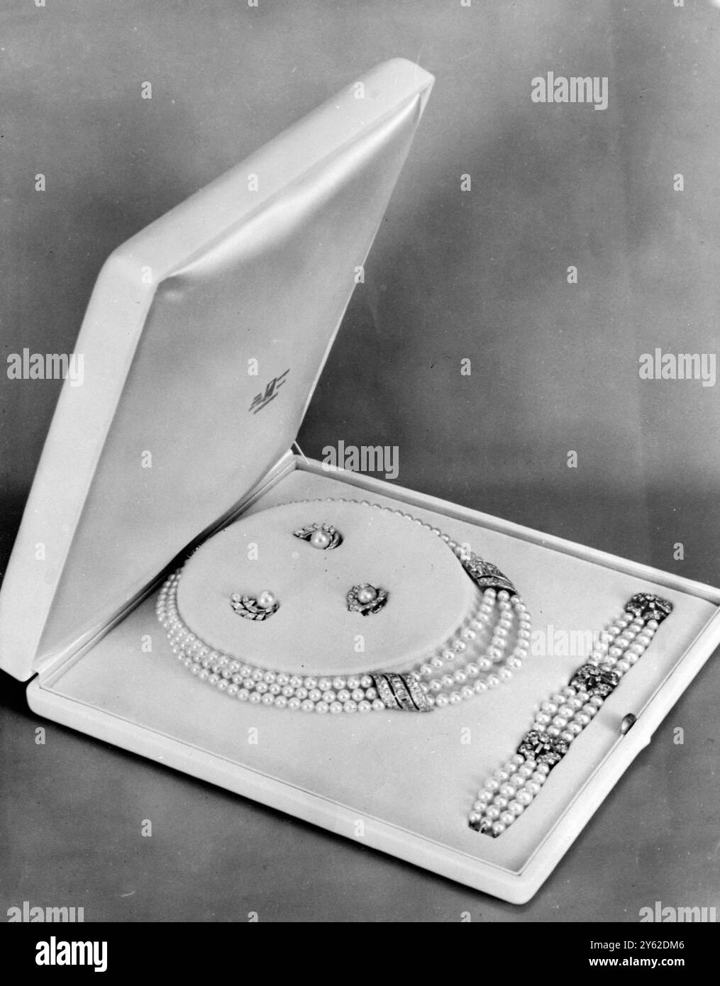 Cadeau de mariage de Rainier à Grace New York : alors qu'il était à New York, le prince Rainier a choisi cet ensemble de perles et de diamants pour le présenter à sa mariée, l'actrice américaine Grace Kelly, le jour de leur mariage. L'ensemble se compose d'un collier de trois perles avec deux ornements de diamant, un bracelet à trois brins avec trois motifs de fleur de diamant, une bague de fleur de diamant avec centre de perle, et des clips d'oreille de perle avec des diamants. 19 avril 1956 Banque D'Images