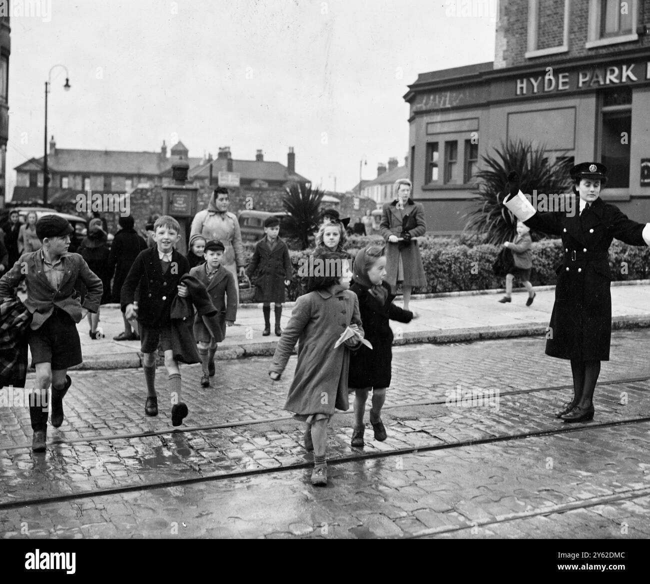 Plymouth la première policière à être en service ponctuel est Miss Iris Martin, 25 ans, vue ici en service à Hyde Park Corner de Plymouth City alors qu'elle dirigeait les enfants en toute sécurité de l'autre côté de la rue. L'introduction de femmes policières à la fonction de point par l'Autorité de Plymouth est une expérience, de sorte que les policiers peuvent être détournés vers d'autres fonctions. D'après les rapports de Miss Martin sur la gestion calme de la circulation animée, l'expérience semble être un succès. 7 décembre 1946 Banque D'Images
