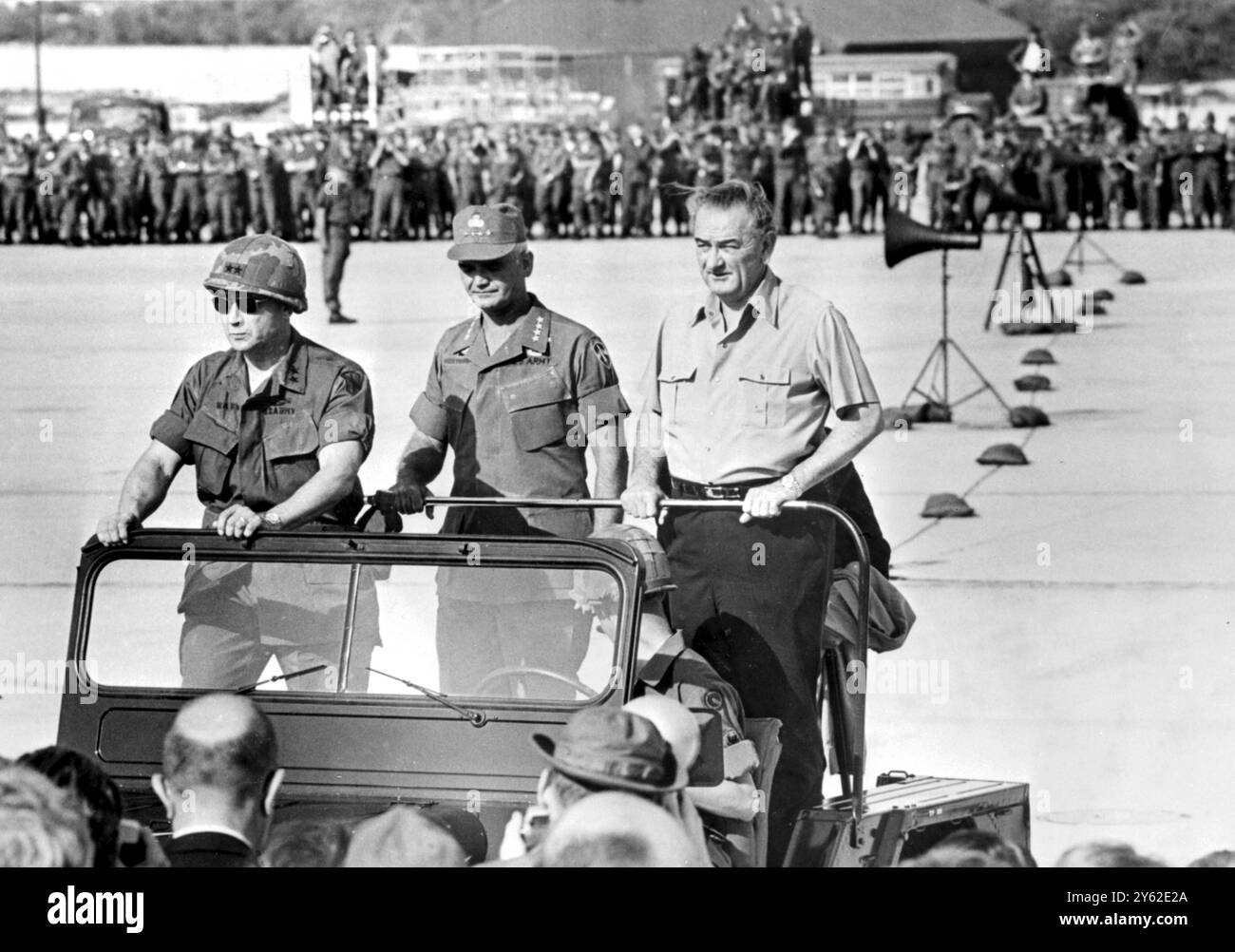 Cam Ranh, Sud Vietnam : le président des États-Unis Lyndon Johnson monte dans une jeep avec le général Westmoreland (Centre) alors qu'il passe en revue les troupes américaines ici le 23 décembre Johnson a passé une heure et 45 minutes à la base du Sud Viet Man, et à la fin de son discours a donné un acclamé vif de toutes les branches des services armés américains. Le président Johnson était sur le chemin du retour de Melbourne, en Australie, à Washington, quand il a assisté au service commémoratif à Harold Holt, le premier ministre australien qui s'est noyé. 28 décembre 1967 Banque D'Images