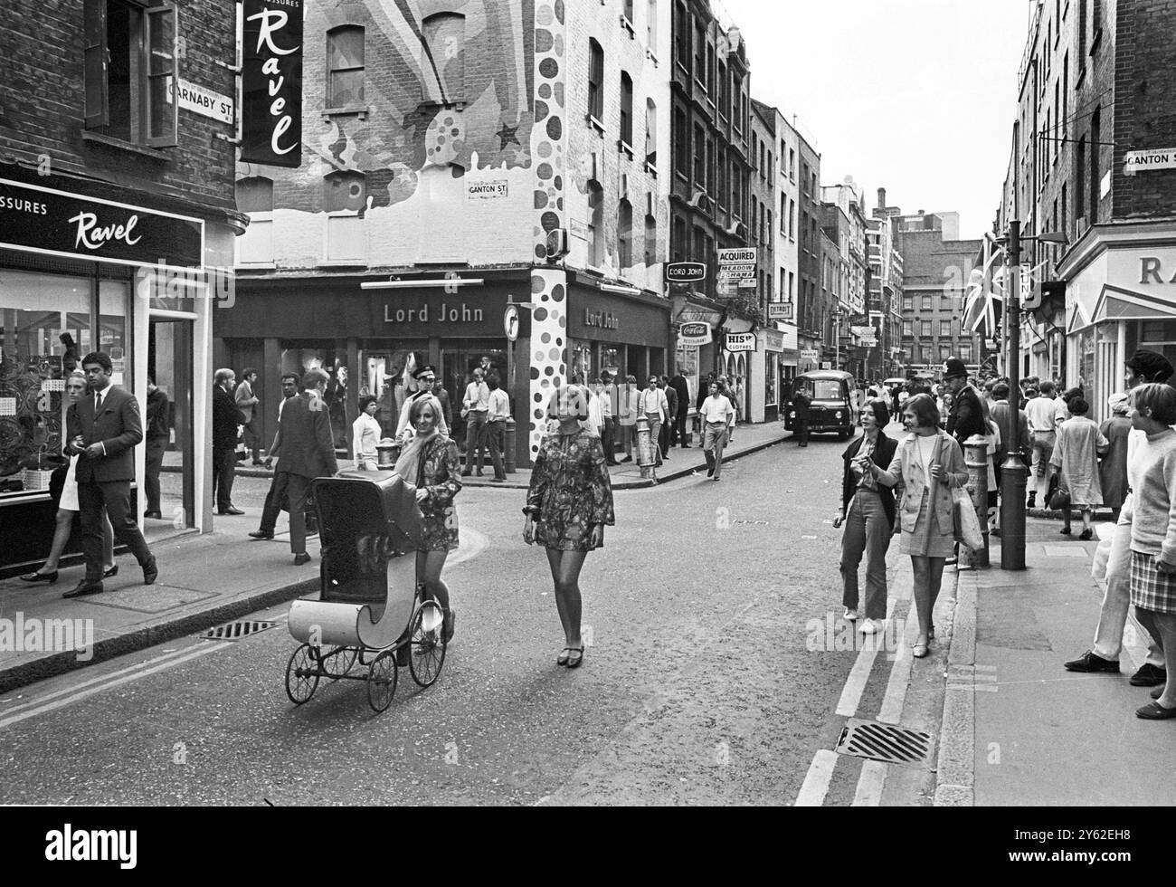 Le centre de la mode londonien pour les plus jeunes est Carnaby Street, la rue la plus connue, sinon la plus populaire de Londres. Les jeunes aux cheveux longs parlent loin les heures à Carnaby Street la Mecque des modes mod de la capitale anglaise tout ce qui va de la mini-jupes aux derniers styles de vestes et pantalons pour hommes peut être acheté à Carnaby Street, le siège de la mode des jeunes 20 juillet 1967 Banque D'Images