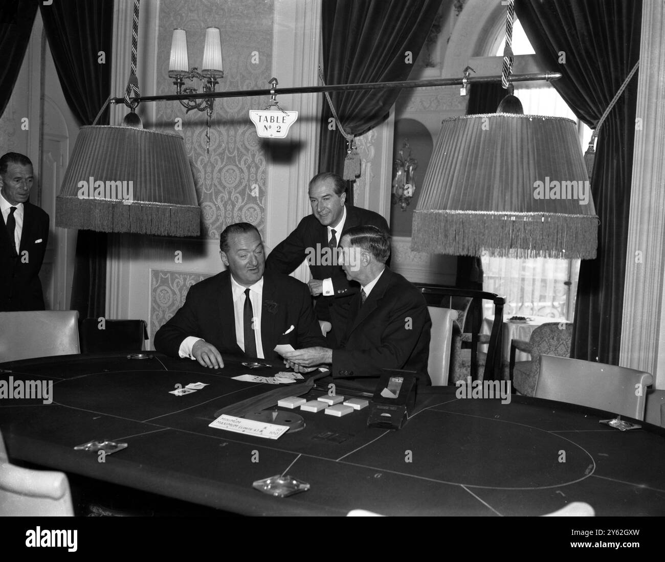 Au cercle des Ambassadeurs , à Hamilton place à Londres, les voix des croupiers importés français appelés sur les tables de baize en répétition pour l'ouverture du premier salon de jeu de Londres . Le club , le plus grand de Londres , fait partie du Club des Ambassadeurs , dirigé par M. John Mills , ancien officier de l'armée polonaise , qui a fondé le club il y a vingt ans . LtorR vu avec Mr Mills sont deux des croupiers M Pierre Bax et M Henri Galliano . 23 mai 1961 Banque D'Images