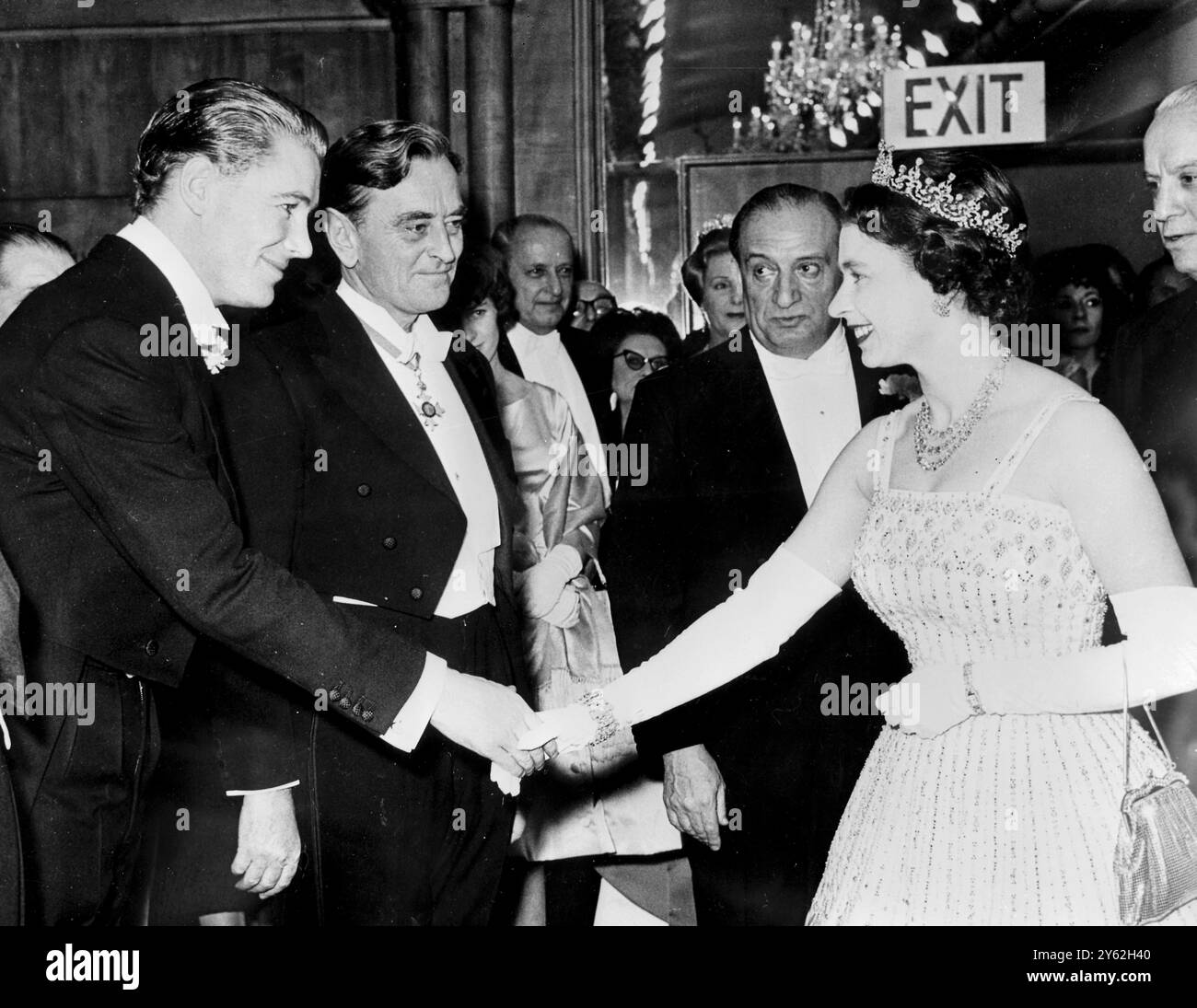 Londres : H.M. Queen serre la main de l'acteur Peter O'Toole qui joue le rôle-titre. Lors de la première caritative de « Lawrence d'Arabie » à Odéon, Leicester Square, Londres. Le centre est David Lean, réalisateur et derrière la Reine, Sam Spiegel, producteur du film. 11 décembre 1962 Banque D'Images