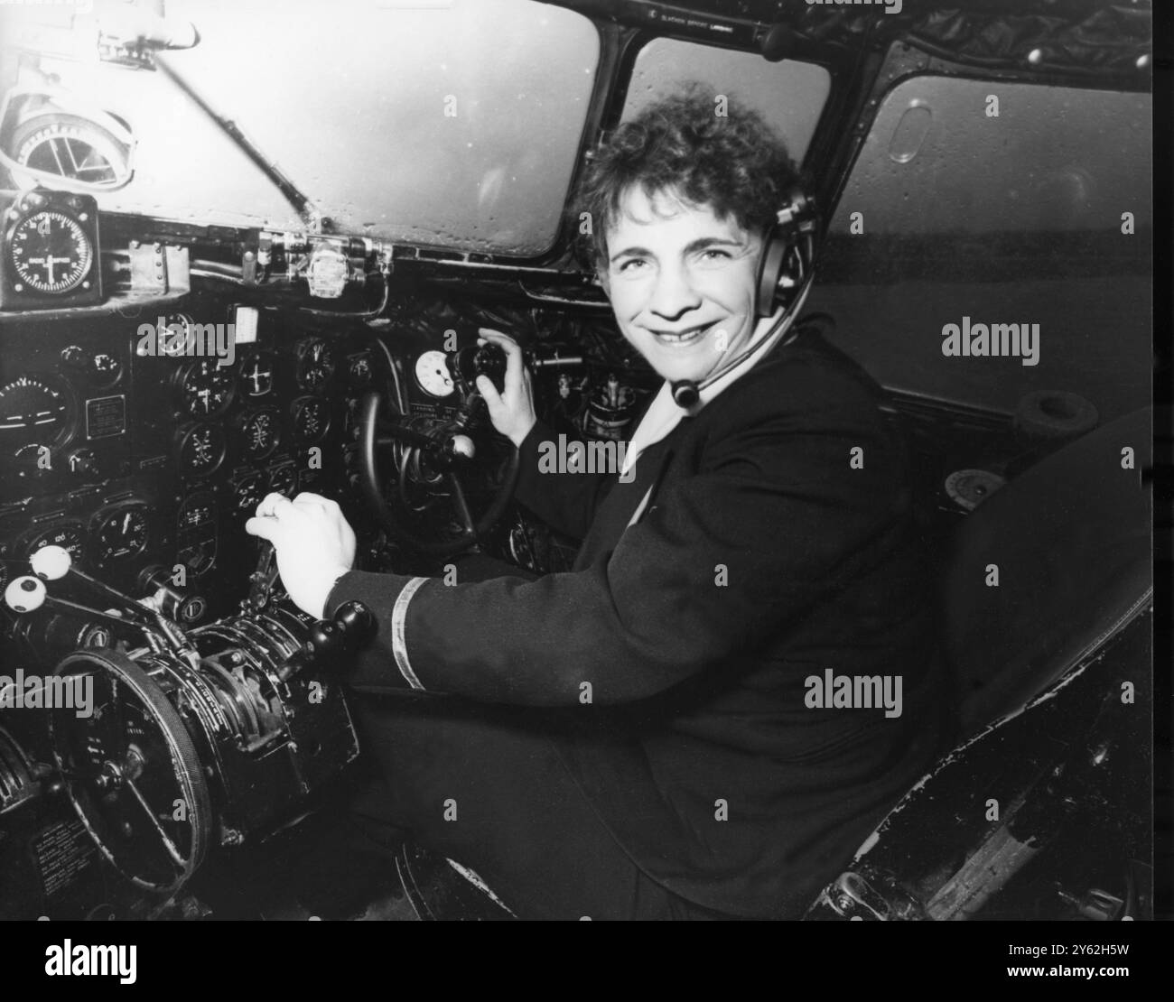 Femme pilote de ligne Gatwick , Angleterre : Mme Yvonne Pope , veuve de 34 ans avec deux jeunes fils, est sur le point de commencer à travailler comme pilote pour l'une des plus grandes compagnies charter de Grande-Bretagne . Mais elle a déjà 2 400 heures de vol à son actif et abandonne son emploi de contrôleur sol d'aéroport pour devenir la première femme pilote de ligne professionnelle de Grande-Bretagne. Son mari ? Il était pilote charter et instructeur de vol. Voici Mme Pope dans le cockpit le 23 décembre 1964 Banque D'Images