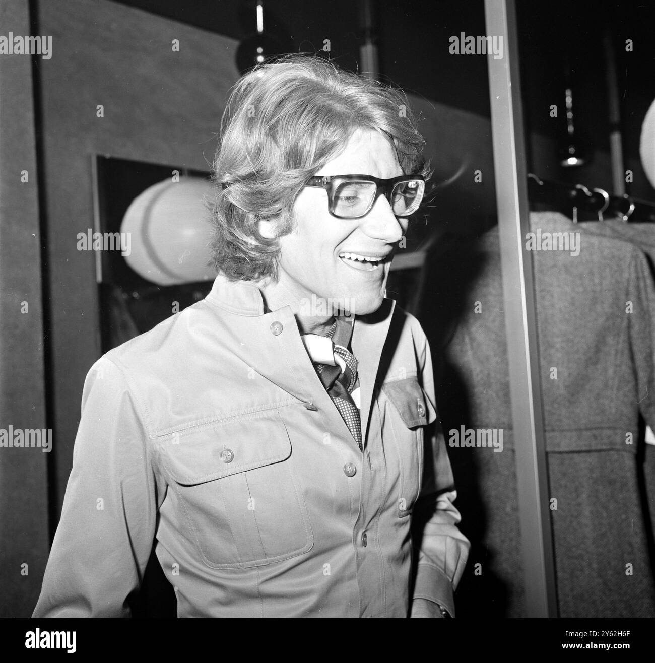 Yves St Laurent , l'un des plus grands créateurs de mode français , qui a repris pendant un certain temps le design de la Dior Fashion House à Paris , photographié devant sa première boutique en Angleterre , après l'ouverture du magasin de prêt-à-porter dans la rue à la mode de Londres Bond Street . Dans sa nouvelle entreprise Wenglish, Elaboration Laurent a des dessins sur des femmes britanniques qui peuvent se permettre de dépenser de £3 à £125 -- Une robe typique St Laurent coûtera environ £25, un costume pantalon £50 . 10 septembre 1969 Banque D'Images