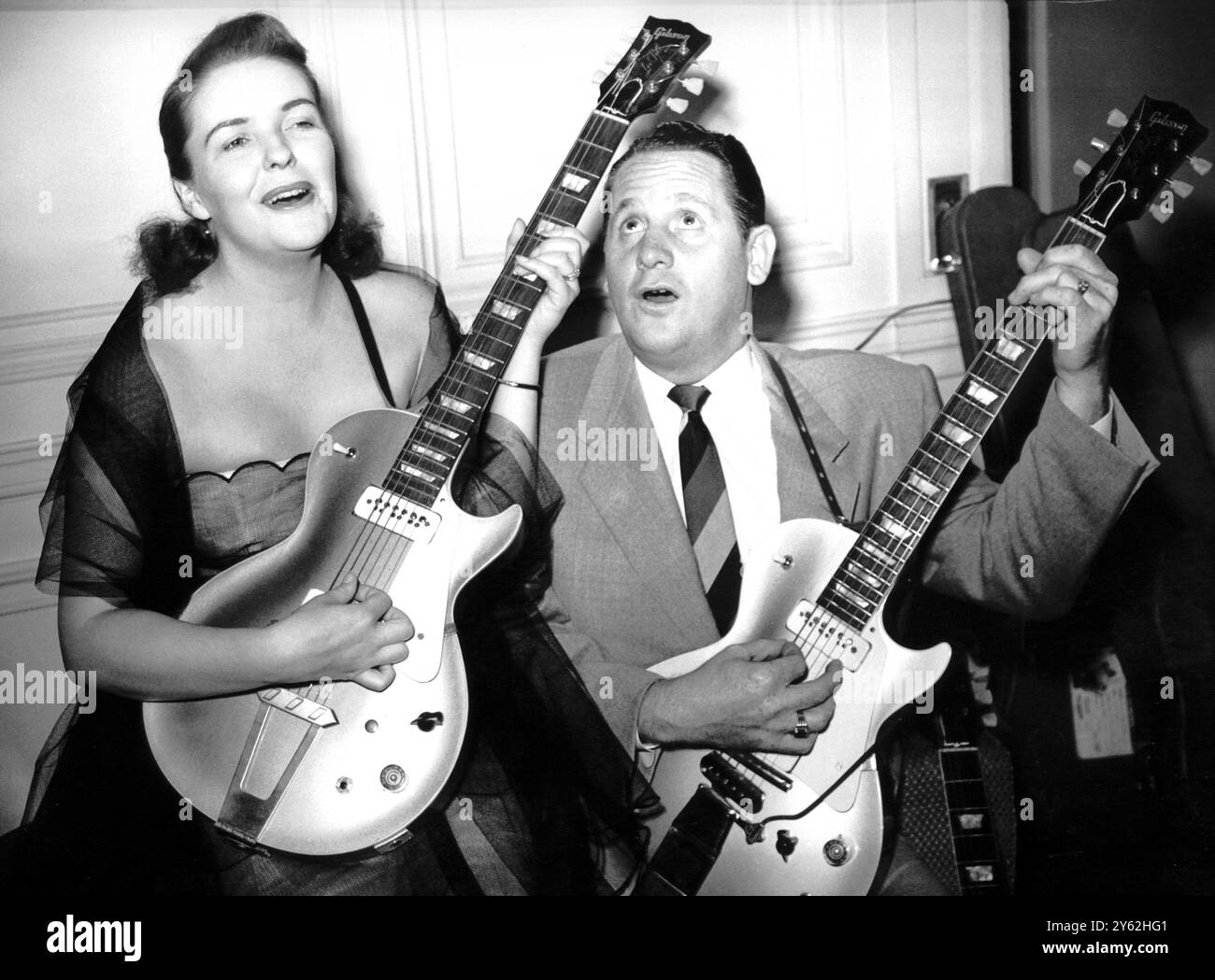 Les Paul et sa femme Mary Ford complètent leurs guitares au Savoy Hotel où ils séjournent pendant leur saison de deux semaines au London palladium. Ils ont une technique célèbre que les a développée dans laquelle quand il joue il sonne comme huit guitares et quand Mary chante il sonne comme une chorale. Leur technique est si secrète que tous leurs enregistrements sont réalisés chez eux. 9 septembre 1952 Banque D'Images