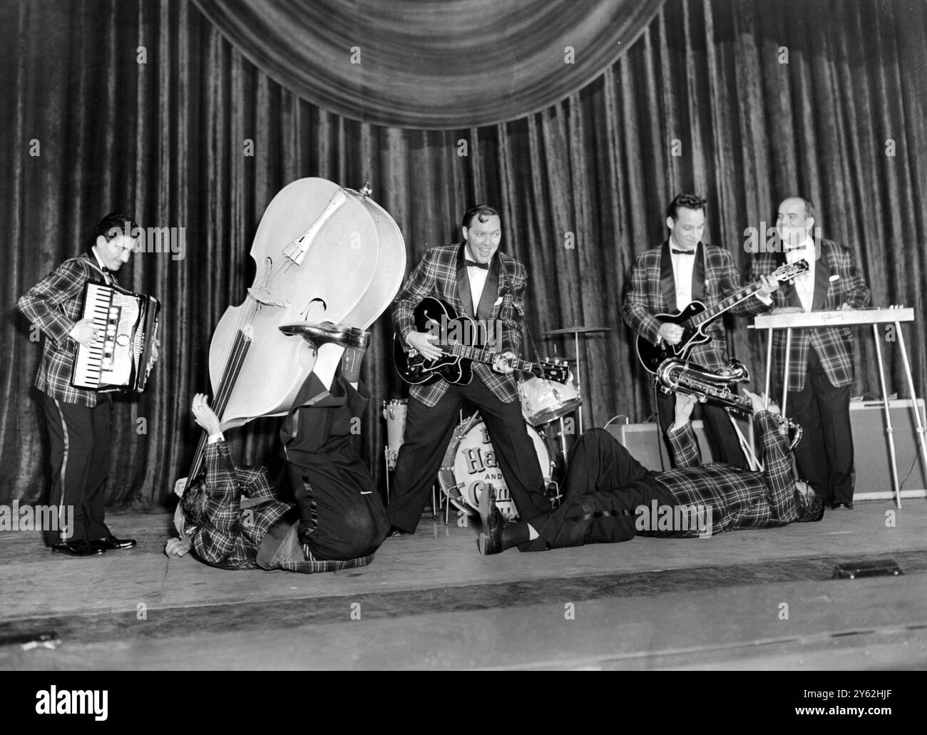 Bill Haley et ses fabuleux lanceurs 'Comets' de l'engouement Rock 'n' Roll, montrent leurs talents polyvalents lors d'une répétition au Dominion Theatre, Tottenham court Road, où ils ouvrent leur tournée britannique ce soir, les garçons sont Johnnie Grande, accordéon ; Al Rex, démontrant un nouveau style de contrebasse ; Bill Haley, guitare ; Ruddy Pompilli, soufflant du saxophone d'une position postrate ; Franny Beecher, guitare électrique ; et Billie Williamson, acier. 6 février 1957. Banque D'Images