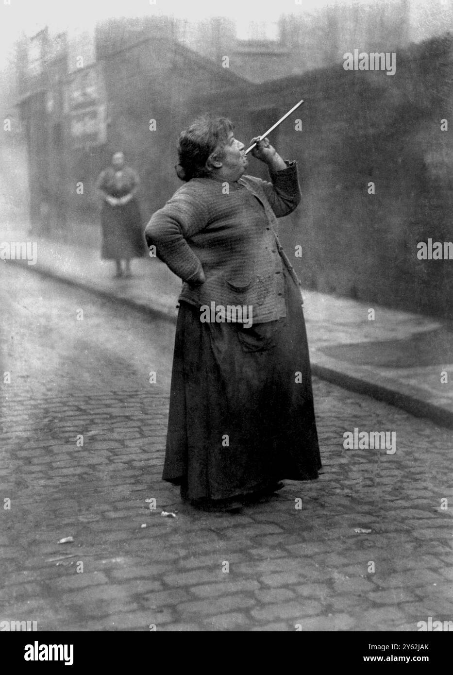 Peu de travailleurs possédaient des réveils, de sorte que les services de ce «knocker up» étaient en demande. Elle réveilla ses clients en tirant des pois à leurs fenêtres. 1931 Banque D'Images