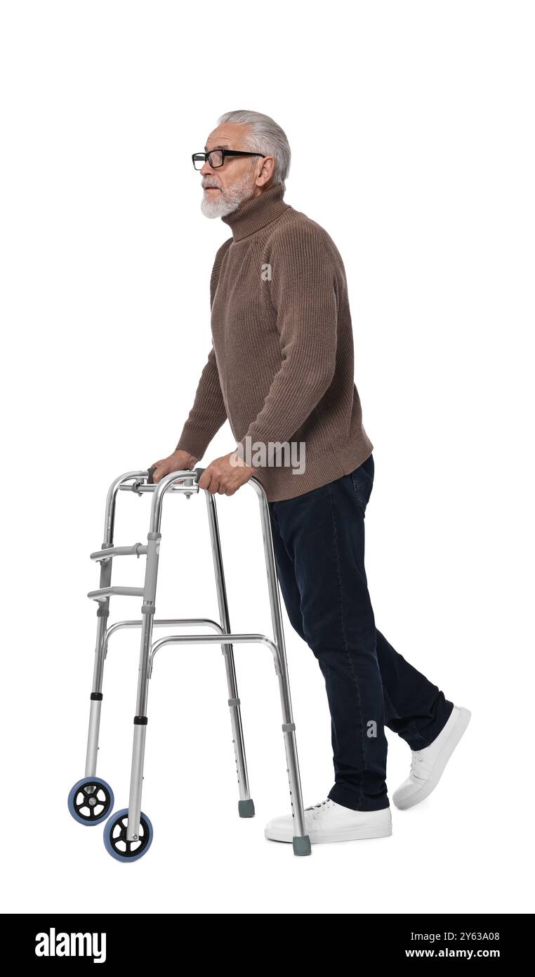 Homme senior utilisant le cadre de marche sur fond blanc Banque D'Images