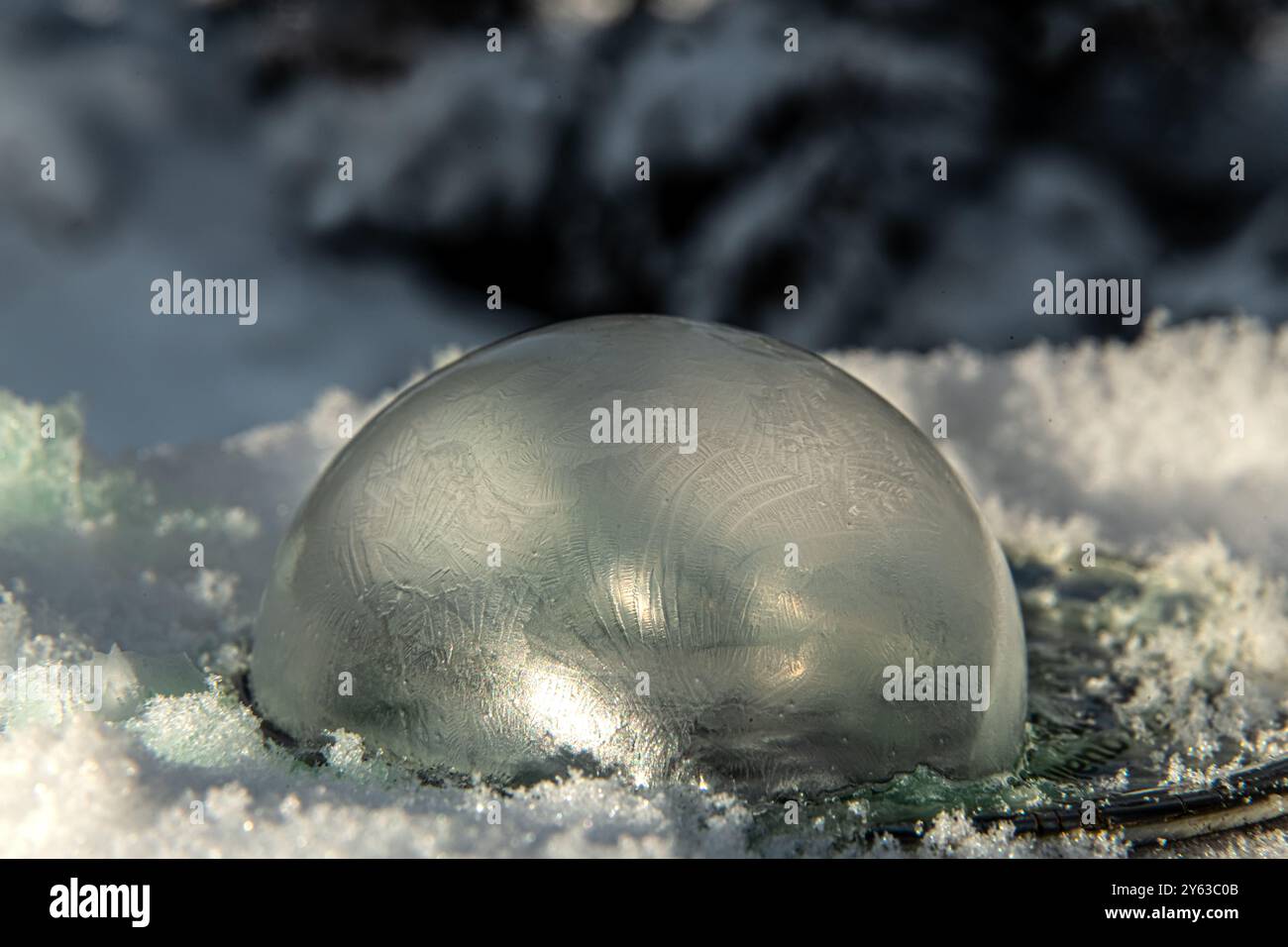 Une bulle de savon congelée montrant une surface texturée glacée et recouverte de glace lors d'une journée 40 en dessous dans le nord du Canada pendant la saison hivernale. Banque D'Images