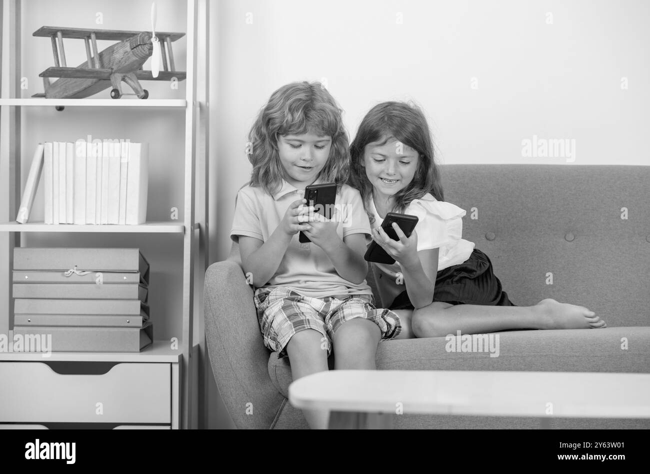 Contrôle parental. Enfants seuls avec téléphone à la maison. Addiction aux médias sociaux. Les enfants amis et l'amitié. Téléphone mobile accro aux enfants. Banque D'Images