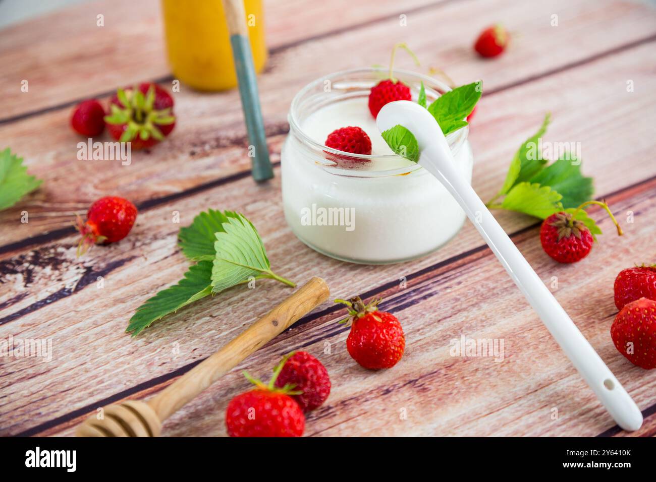yaourt sucré maison dans un pot avec des fraises, sur une table en bois. Banque D'Images