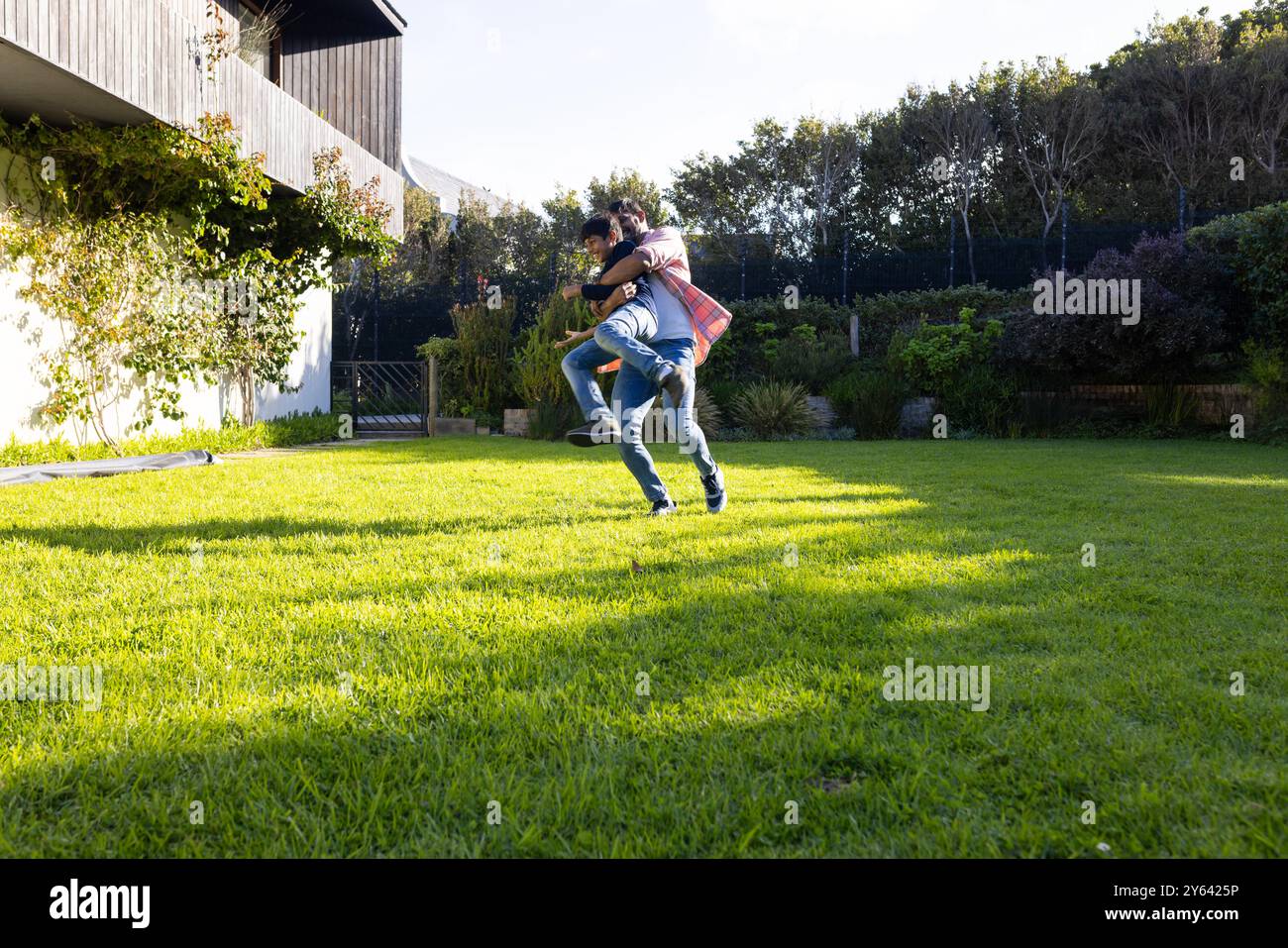 père indien portant le jeune fils sur le dos, jouant ensemble dans le jardin de l'arrière-cour, espace de copie Banque D'Images