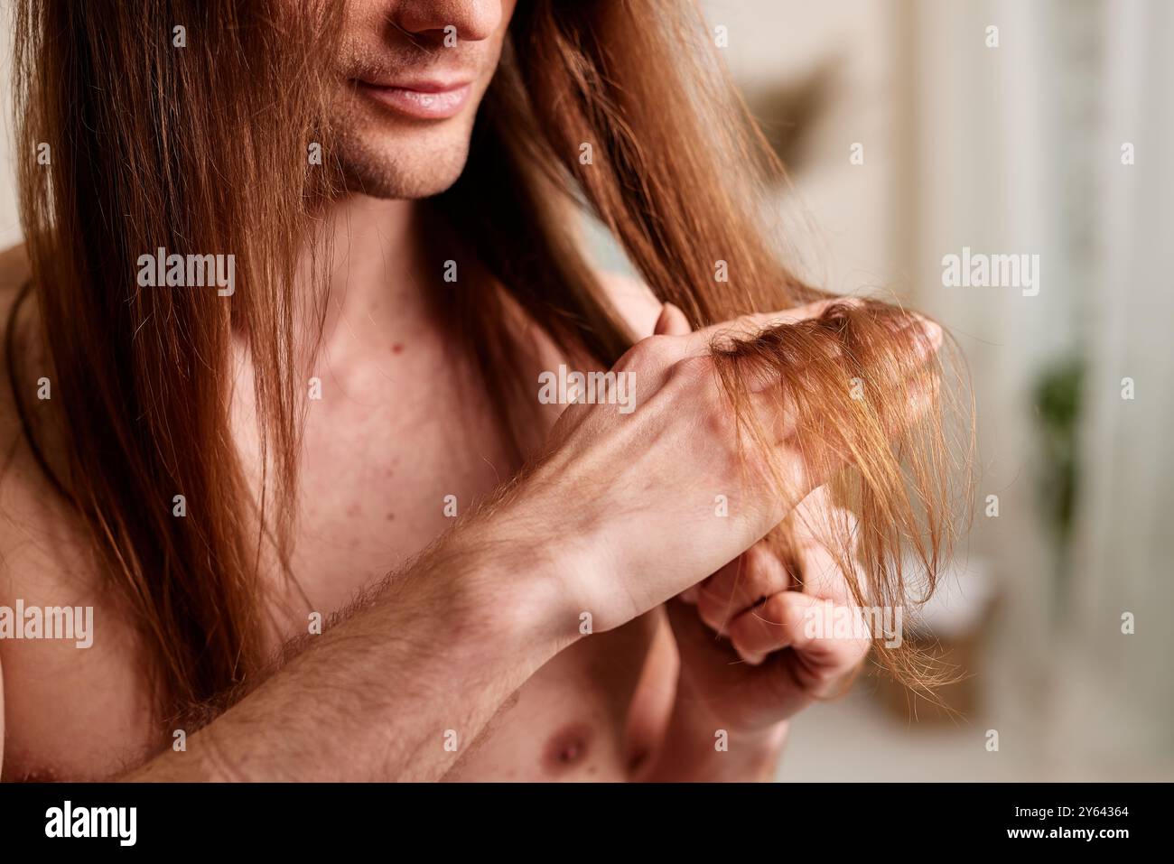 Concept de soins capillaires pour hommes. Jeune homme regardant ses cheveux, problèmes de cheveux chez les hommes, perte de cheveux Banque D'Images