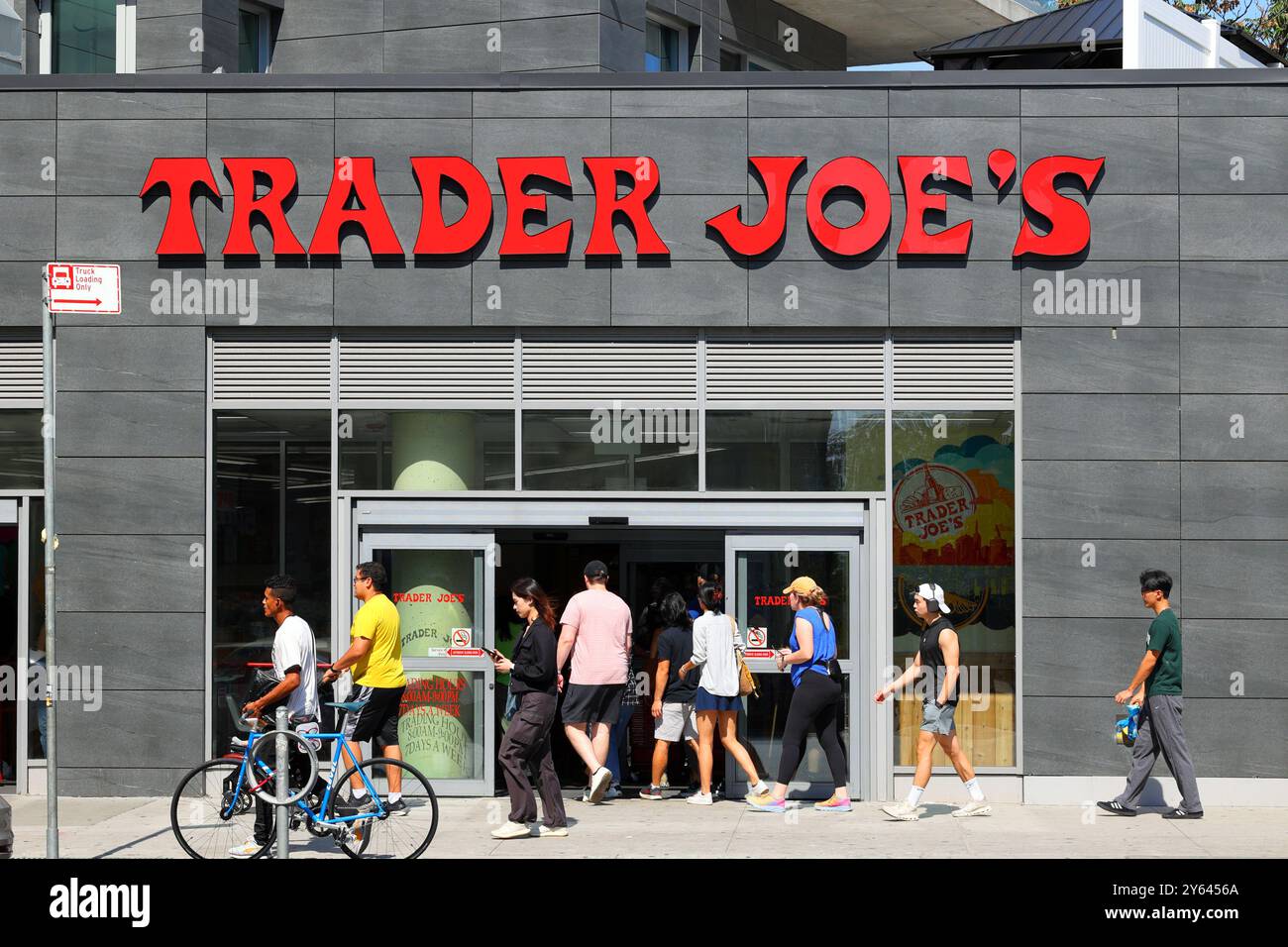 Des gens, des jeunes adultes, entrant dans une épicerie Trader Joe dans le quartier de long Island City à New York. trader joes Banque D'Images