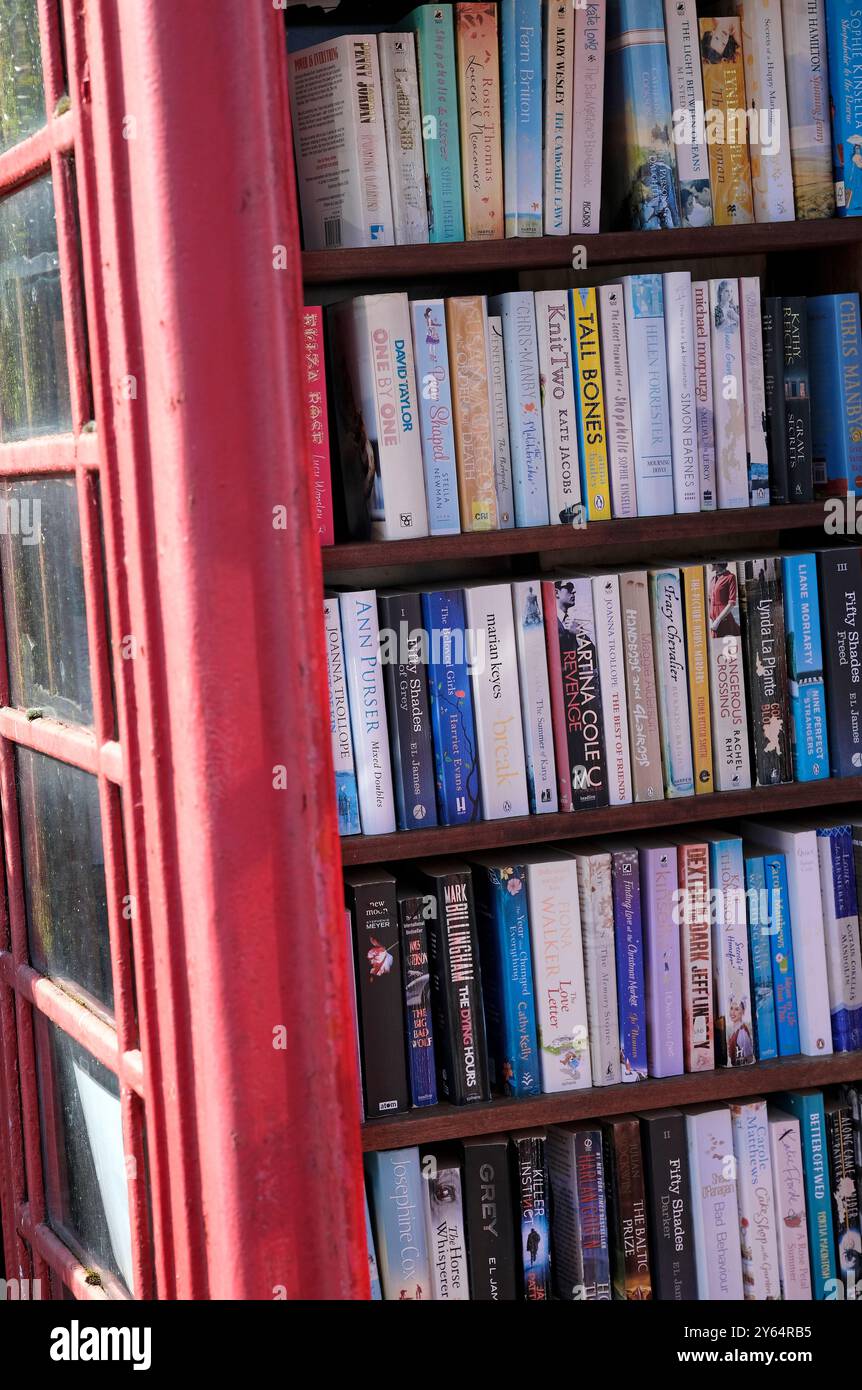 livres de poche dans la bibliothèque rouge de la cabine téléphonique Banque D'Images
