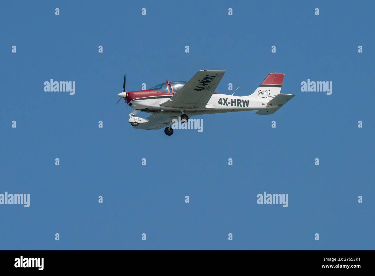 Tel Aviv, Israël - 20 juillet 2024 : un avion léger de couleur rouge et blanche en vol dans un ciel bleu clair. Banque D'Images