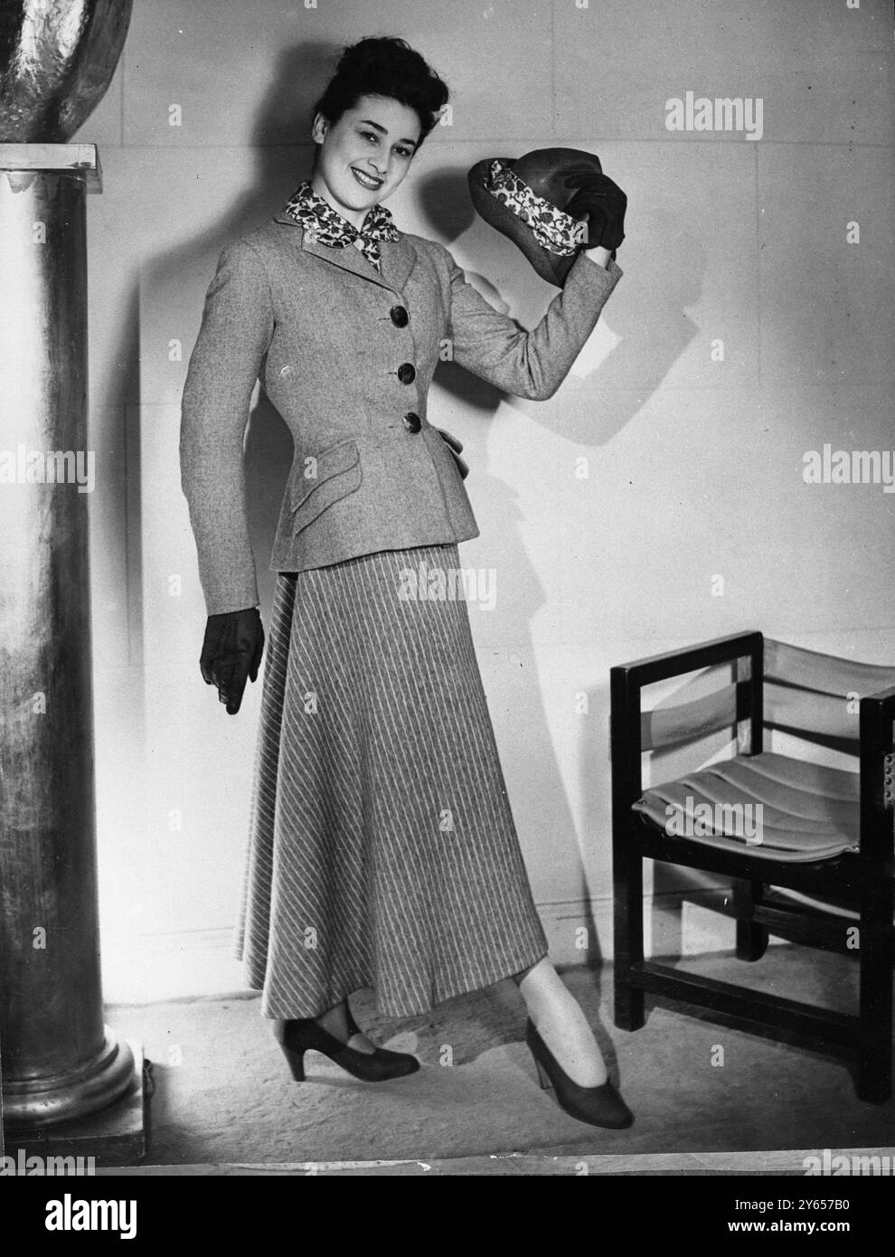 Une des dernières créations printanières de Paris - Madame portera ce costume gris , avec jupe blanche rayée grise - un chemisier et une écharpe de rose et vert ce printemps. Il s'agit d'une création Schiaparelli 1948 Banque D'Images