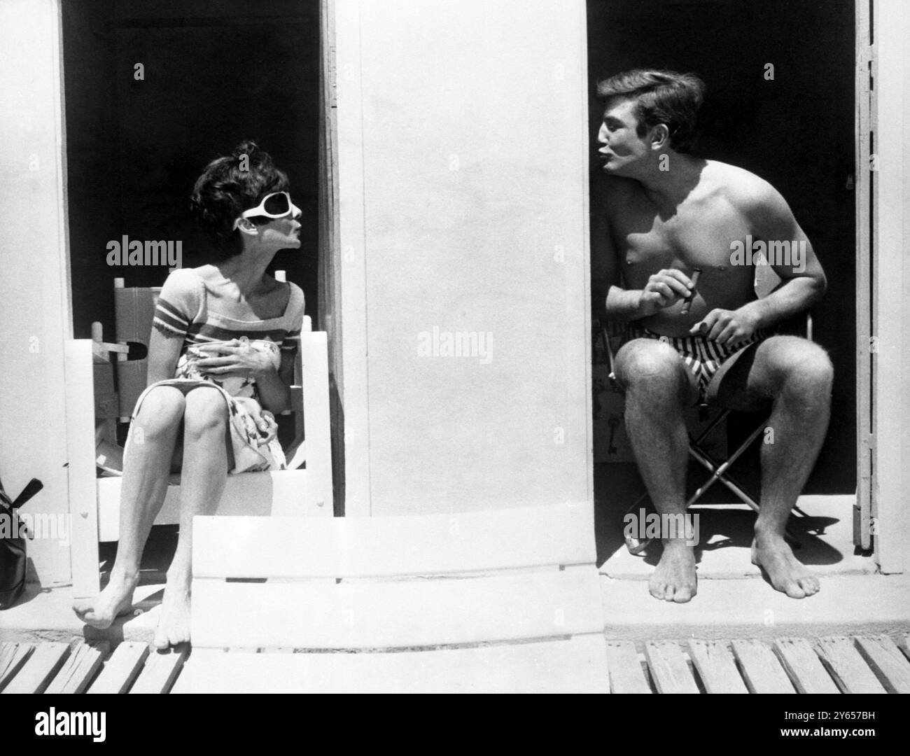 Un toucher du soleil ...il fait trop chaud pour se déplacer ... de sorte que le mur obtient le baiser ... clown autour entre les plans de leur nouveau film 'deux pour la route', sont l'actrice Audrey Hepburn (à gauche) et l'acteur Albert Finney (à droite). Ils se détendent dans des cabanes de plage sur la plage isolée de Beauallon près de St Tropez, où le film est sur place. 10 juin 1966 Banque D'Images