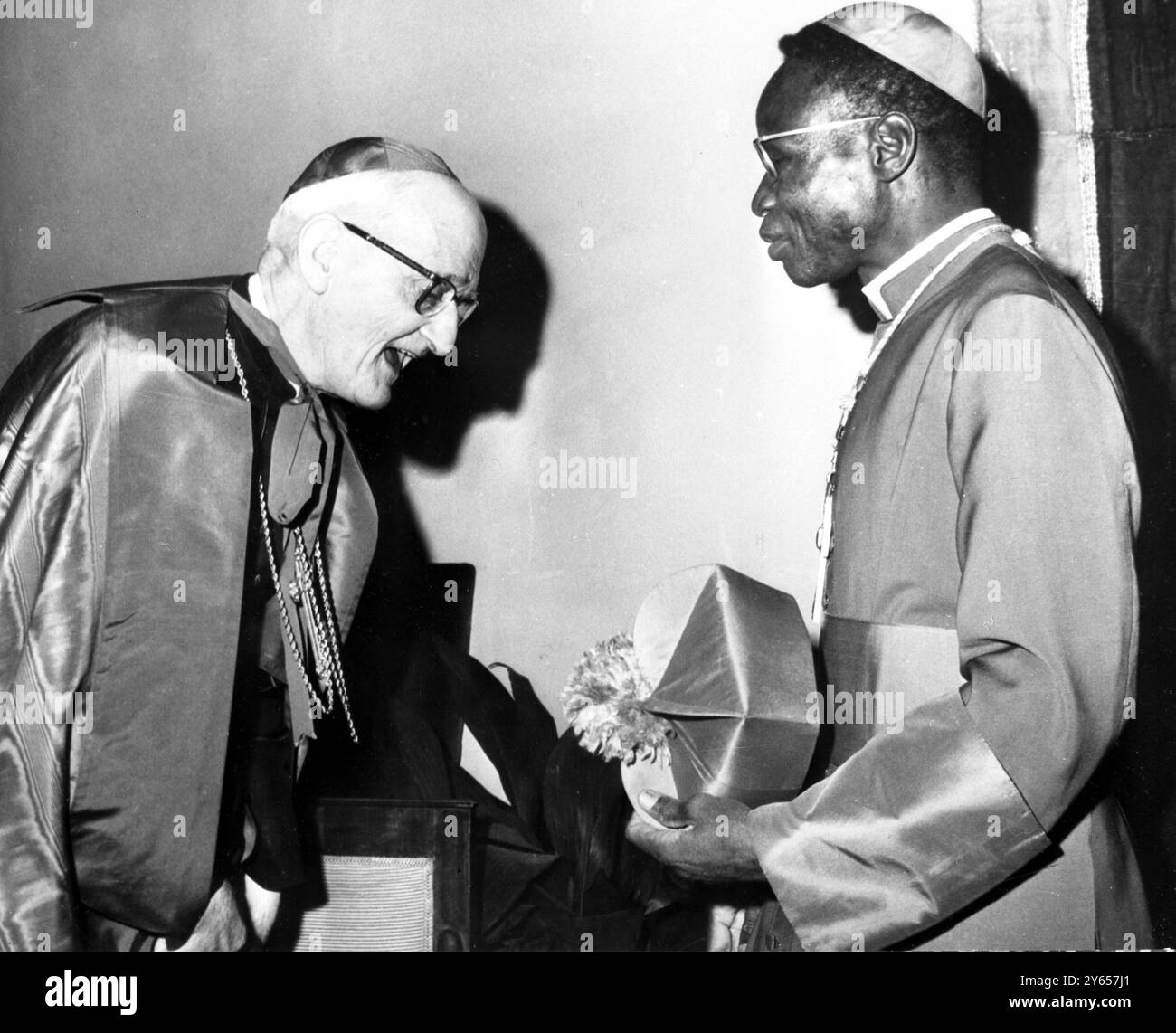 Nouveau Cardinal noir . - Rome ; le cardinal britannique Theodore Heard (à gauche) félicite le nouveau cardinal noir Paul Zoungrana, archevêque de Ouagadougou (haute-Volta), après que ce dernier ait reçu son ' ticket d'investiture ' au Collège nord-américain de Rome, le 22 février, lors de cérémonies liées à l'élévation de 27 prélats récemment nommés par le pape Paul VI au rang de cardinal . - 24 février 1965 Banque D'Images