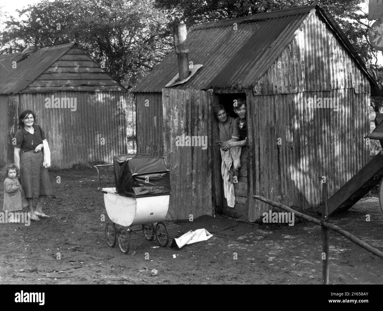 Voici M. Philip Rye et sa femme , qui vivent depuis six ans et demi avec leurs six enfants dans la cabane représentée sur la photo , où il n'y a ni éclairage, ni fenêtres, ni assainissement, ni eau courante . Les enfants vont de un à six ans. Crockenhill , Kent , Angleterre . 5 novembre 1948 Banque D'Images
