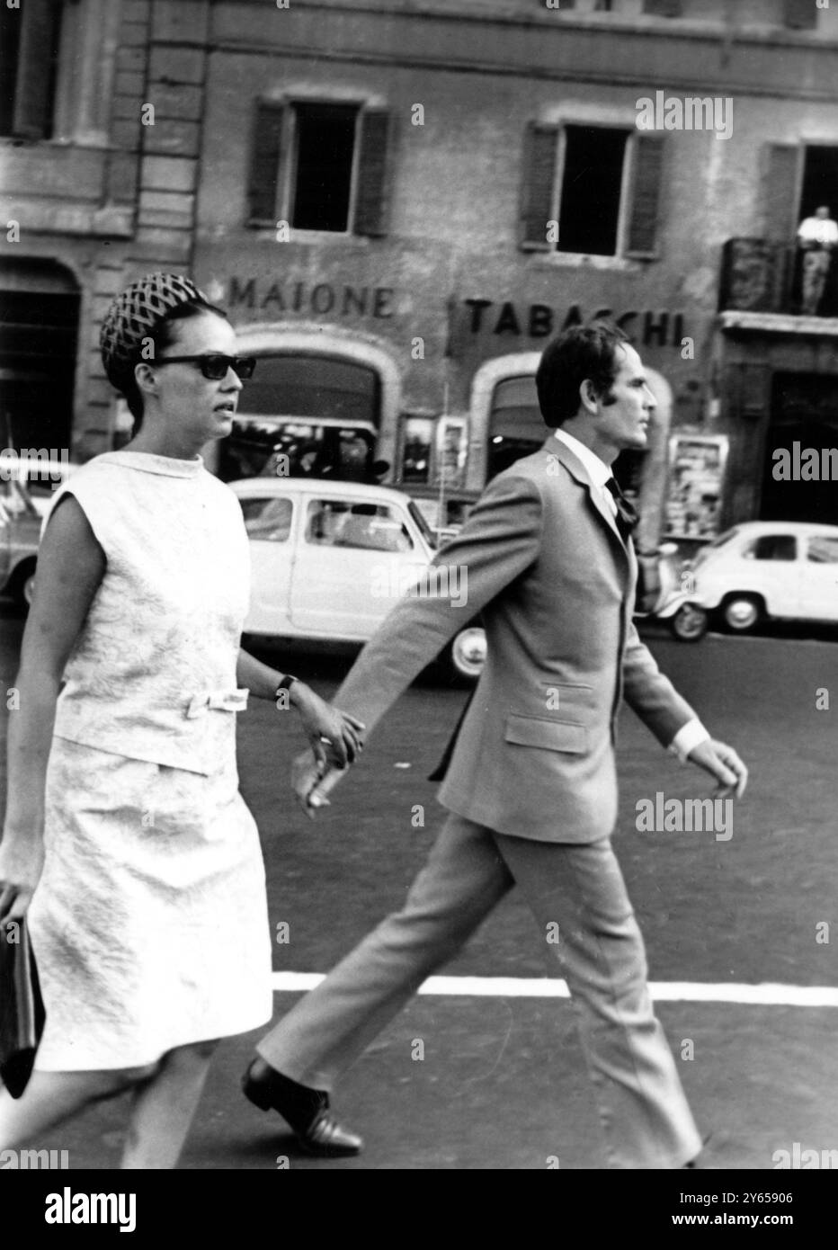 Romance commerciale de Rag ? Rome ; on dirait que la mode a embrassé le théâtre . Séjournant à Rome sont le roi de la mode française Pierre Cardin et l'actrice Jeanne Moreau . Les deux ont été des compagnons constants pendant un certain temps. Personne ne sait s'il y a une romance réelle .... et le couple est enclin à être sensible à propos des caméras... comme lors de cette balade qui s'est transformée en foulée quand ils ont été repérés. 5 juin 1964 Banque D'Images