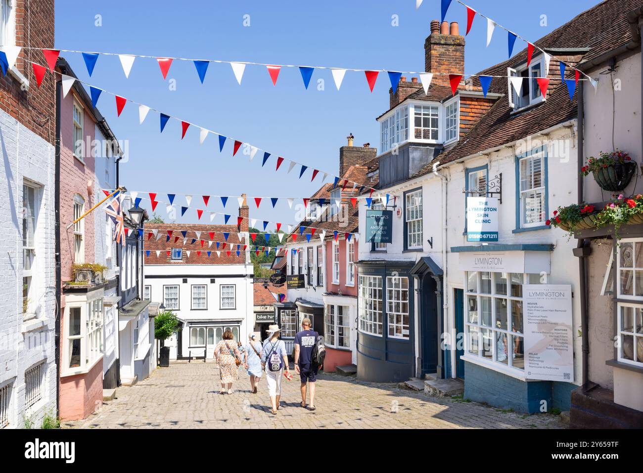 Lymington Hampshire - les gens marchent sur Quay Hill une rue escarpée avec Bunting à Lymington une ville dans la New Forest Hampshire Angleterre GB Europe Banque D'Images