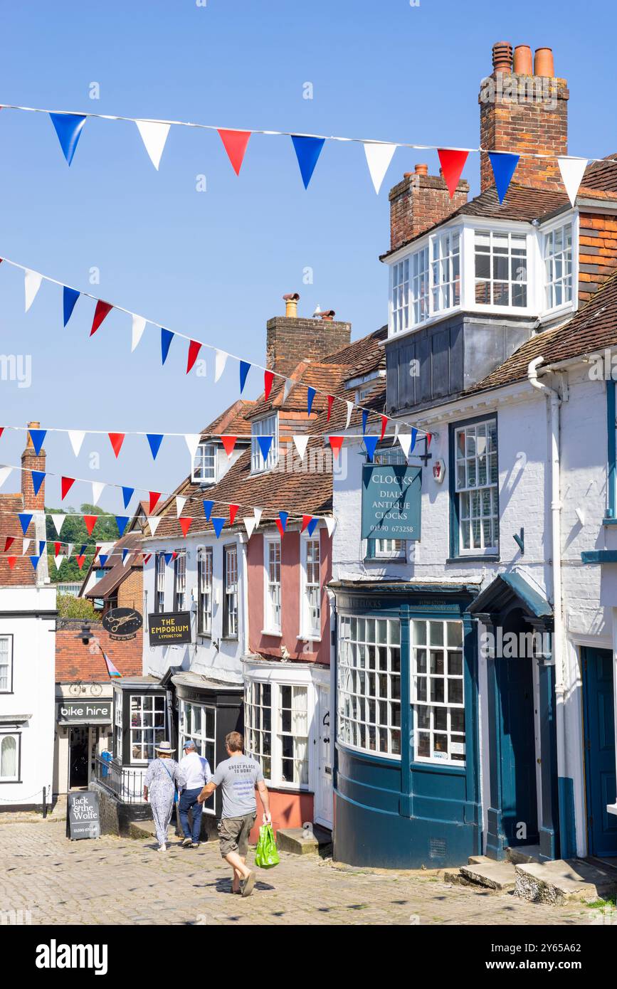 Lymington Quay Hill - les gens marchent dans la rue escarpée avec Bunting dans Lymington Hampshire une ville dans la New Forest Hampshire Angleterre GB Europe Banque D'Images
