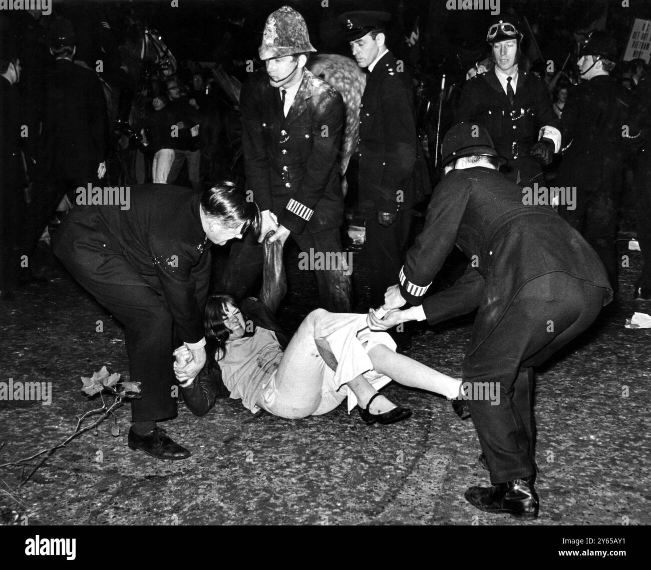 Protestation contre la guerre du Vietnam Londres trois policiers - dont un étouffé de farine - luttent avec une fille devant l'ambassade américaine à Londres lors de manifestations contre la participation américaine à la guerre du Vietnam . 22 octobre 1967 Banque D'Images