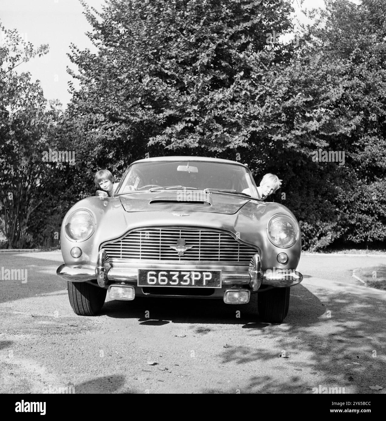 La voiture Goldfinger d'origine achetée par M. Gavin Keyzar 14 mois auparavant est maintenant en vente à nouveau . Tous les objets originaux qu'il avait dans le film avaient été enlevés à part le numéro d'enregistrement original BMP216 . M. Keyzar , 35 ans , directeur de Chislehurst , Kent , dit que l'Aston Martin DB 5 , devient trop petite pour ses deux enfants , Nicolette 6 et Lucinda 3 . "Comme ma voiture est la voiture Bond d'origine, je m'attends à un bon prix", dit M. Keyzar . 21 octobre 1969 Banque D'Images