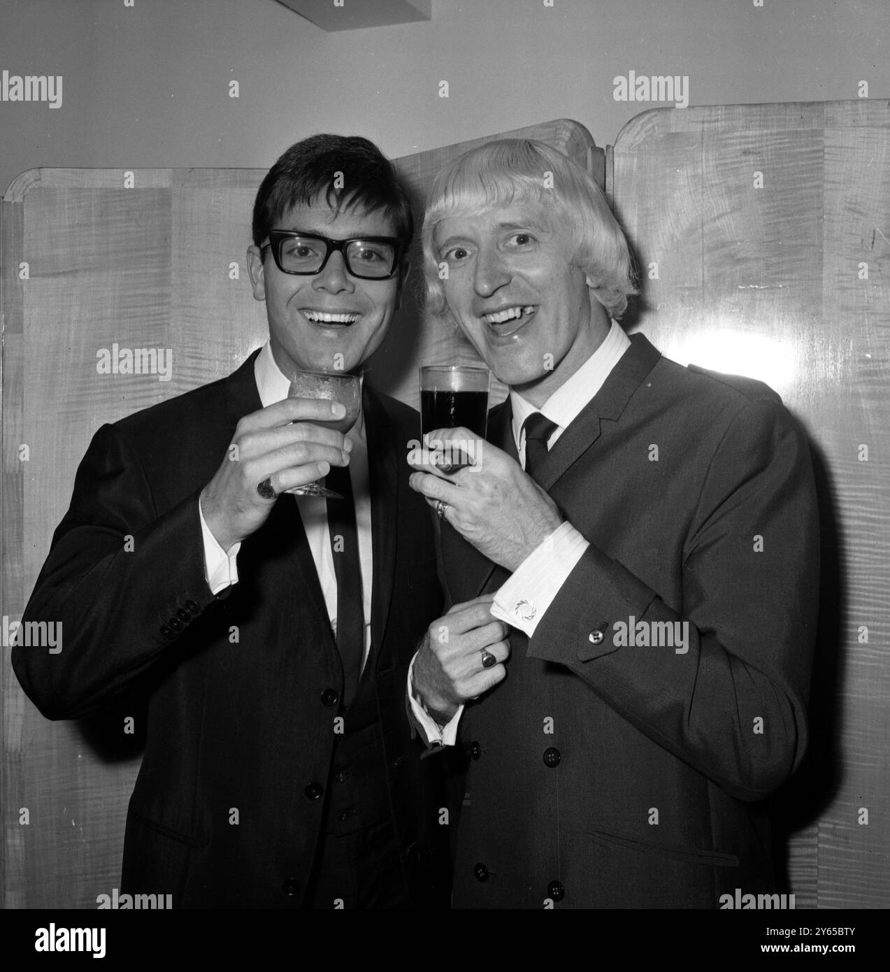 Cliff Richard et Jimmy Savile, le disc-jockey de la pop, se sont toastés à l'hôtel Savoy à l'heure du déjeuner aujourd'hui, où ils ont assisté à un déjeuner du Variety Club. Ils figuraient parmi les lauréats qui ont reçu des prix. 14 septembre 1965 Banque D'Images