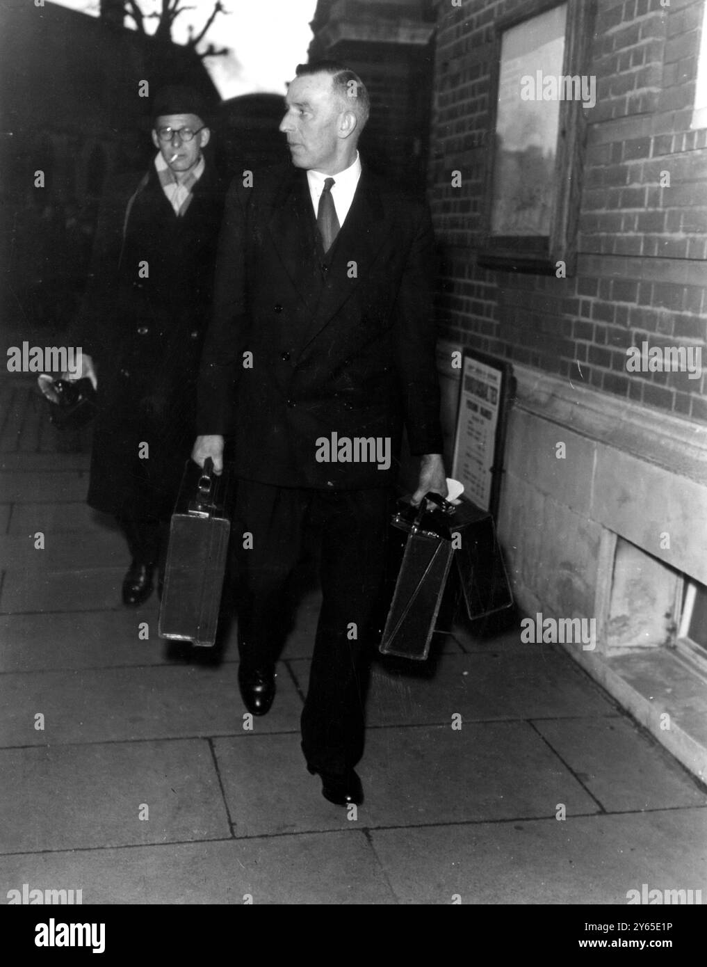 Un sergent détective en civil transporte les deux cas médicaux du Dr John Bodkin Adams dans une main de la Cour d'Eastbourne à la conclusion de l'audience de l'affaire contre le médecin , Adams , qui est accusé du meurtre de Mme Edith Morrell , 81 ans , avec de la drogue en 1950 , a été incarcéré pour un procès au Old Bailey . La Couronne dit qu'il a également tué M. Alfred Hullett , 71 ans , et Mme Gertrude Hullett , 50 ans , et en a profité sous leur testament . La Couronne a terminé sa cause après une audience qui a duré neuf jours. 24 janvier 1957 Banque D'Images