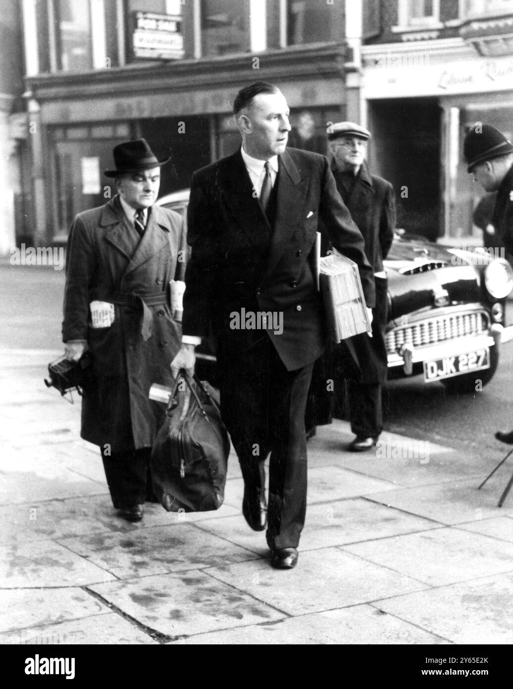 L'audition de l'affaire contre le Dr John Bodkin Adams , accusé du meurtre de la riche veuve Mme Edith Morrell par la drogue , s'est poursuivie au tribunal de première instance d'Eastbourne . Le sergent détective Sellars arrive à la cour avec une quantité de livres qui doivent être utilisés comme preuve dans l'affaire . 17 janvier 1957 Banque D'Images