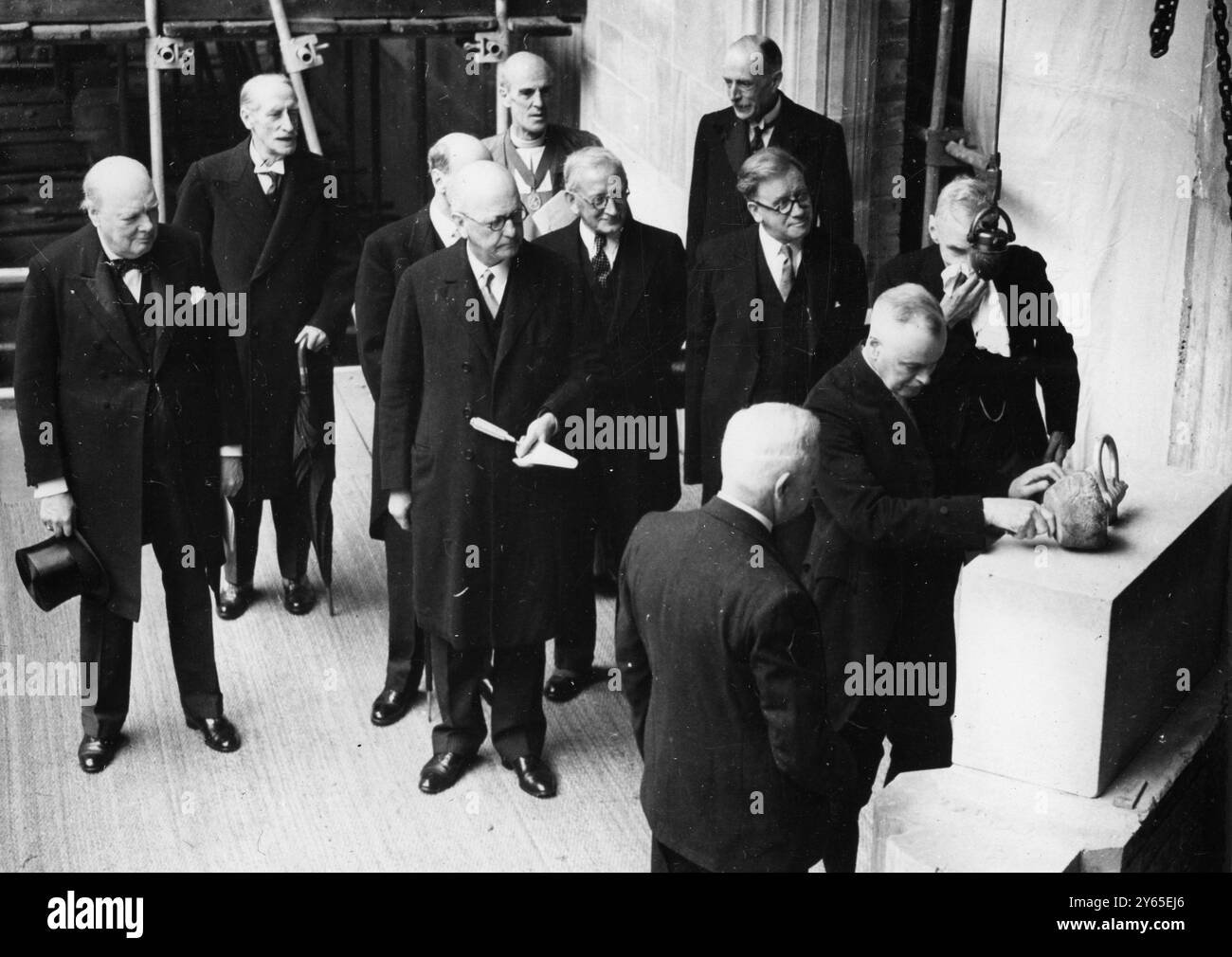Le Président pose la pierre de la nouvelle Chambre des communes . Colonel Clifton Brown posant la première pierre de la nouvelle Chambre des communes , sous la surveillance de M. Winston Churchill , extrême gauche , et des députés , y compris M. Herbert Morrison ( deuxième à partir de la droite , derrière le Président ) le 26 mai 1948 Banque D'Images